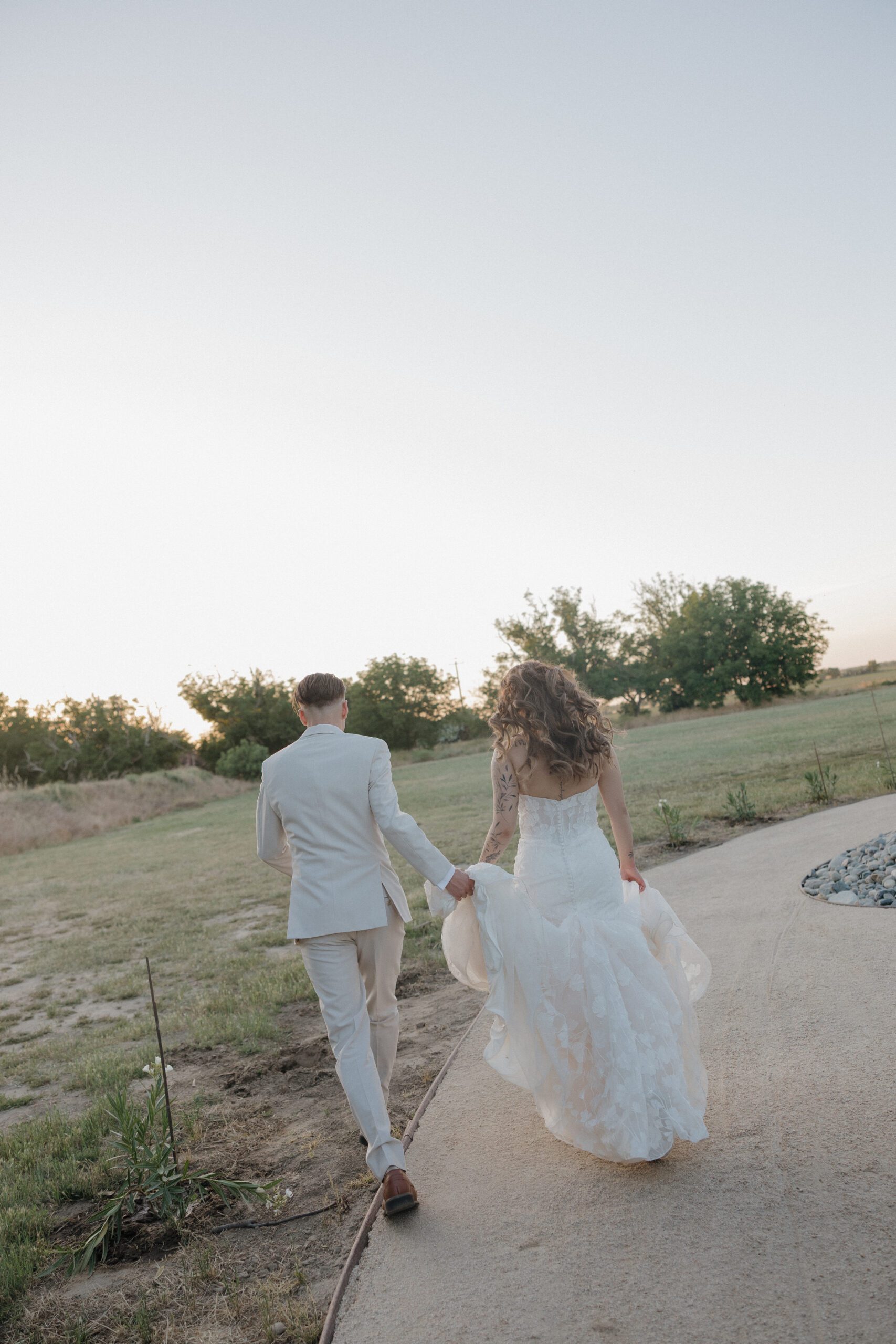 Bride and groom running for wedding photos at golden hour