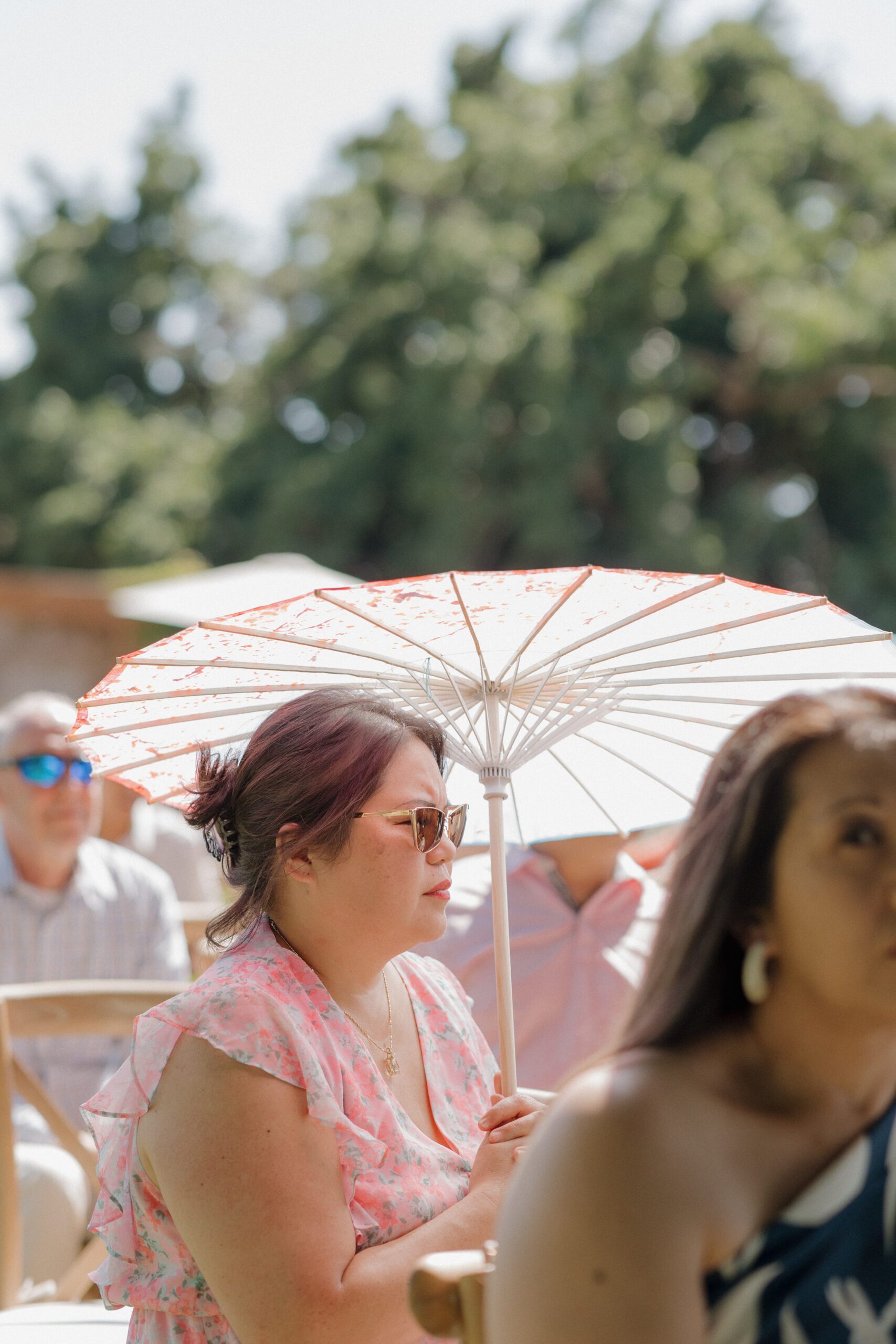A wedding guest holding a parasol at a garden party wedding