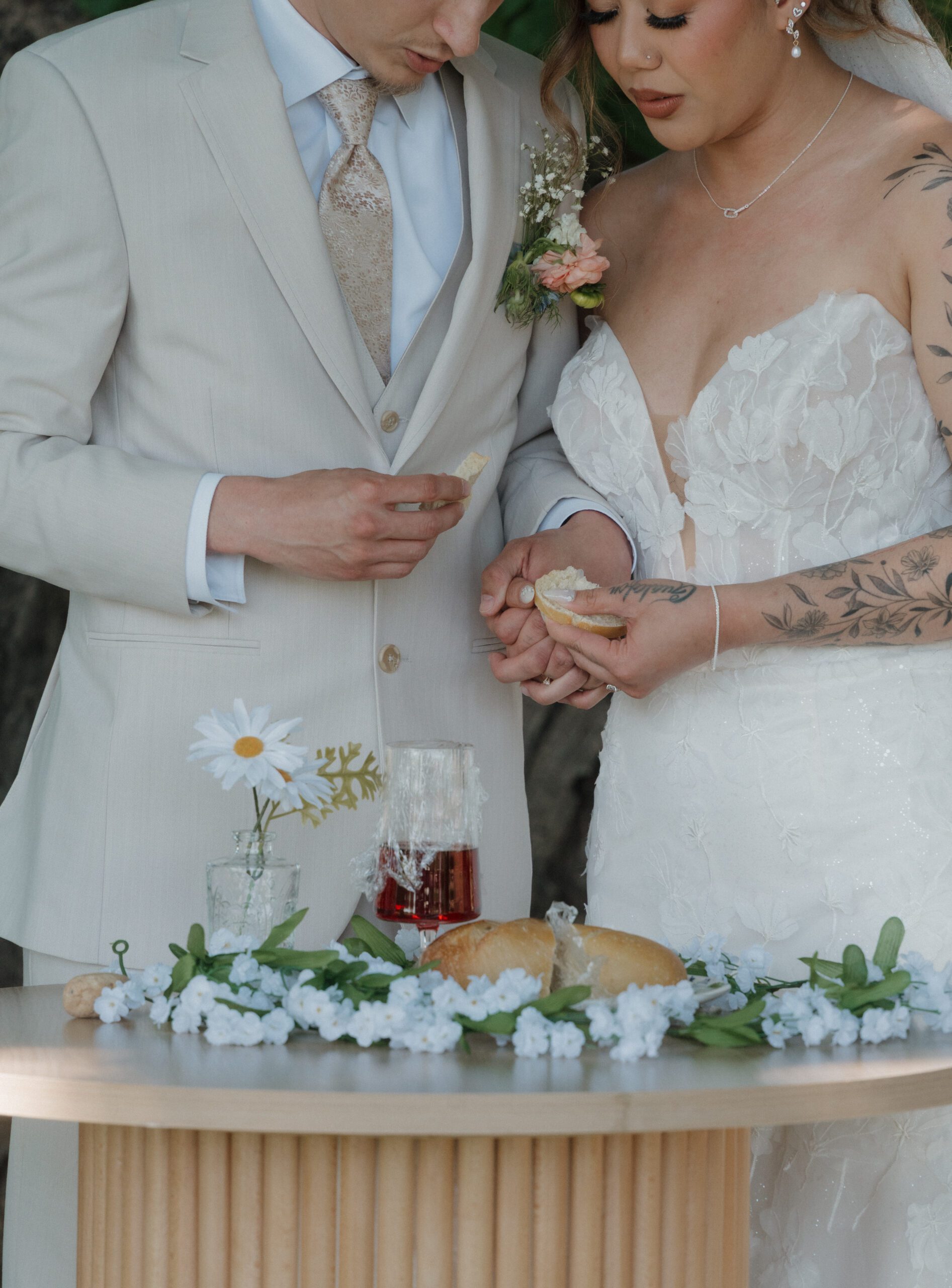 A couple braking bread at their wedding ceremony