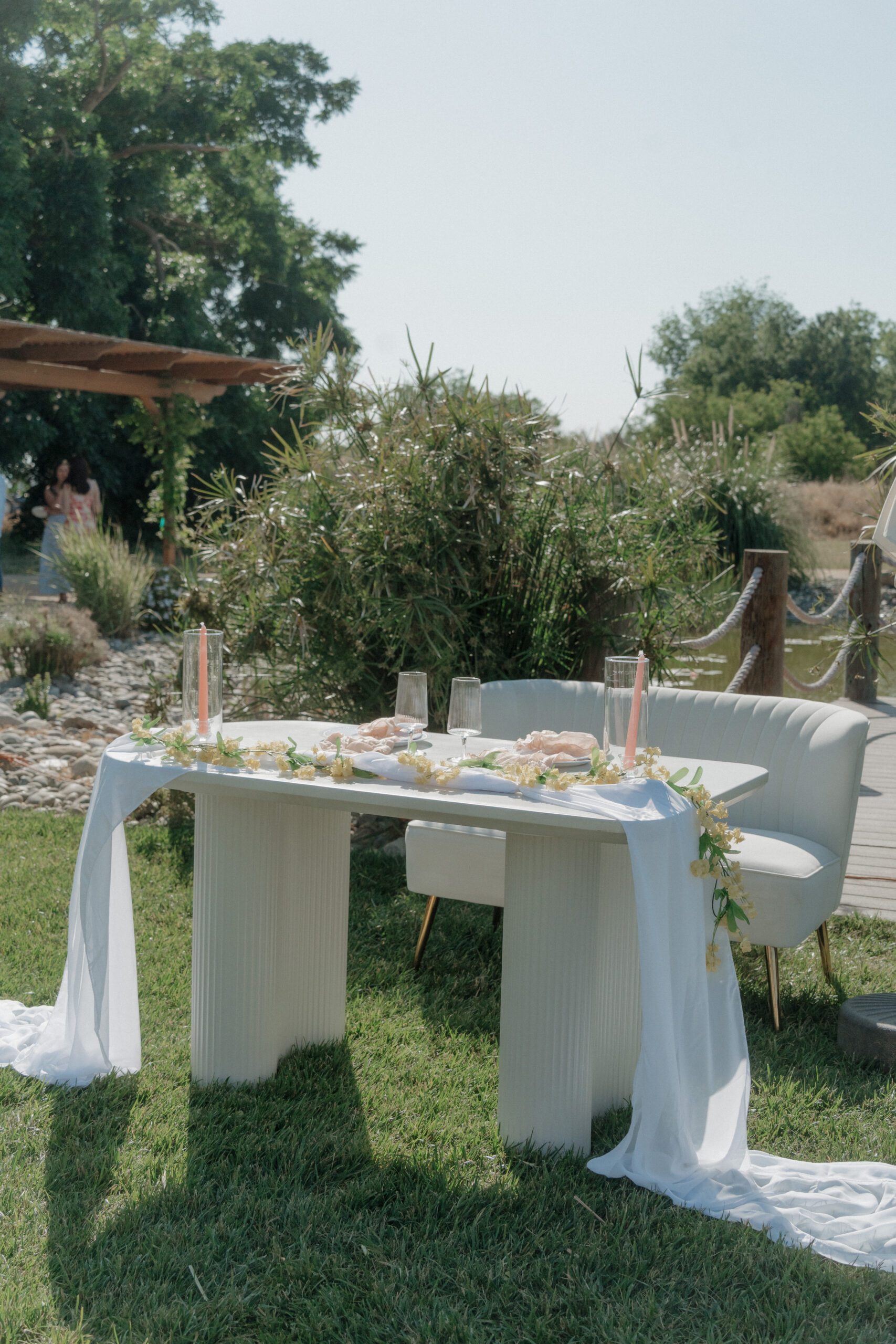 A sweetheart table at an outdoor wedding reception with a couch