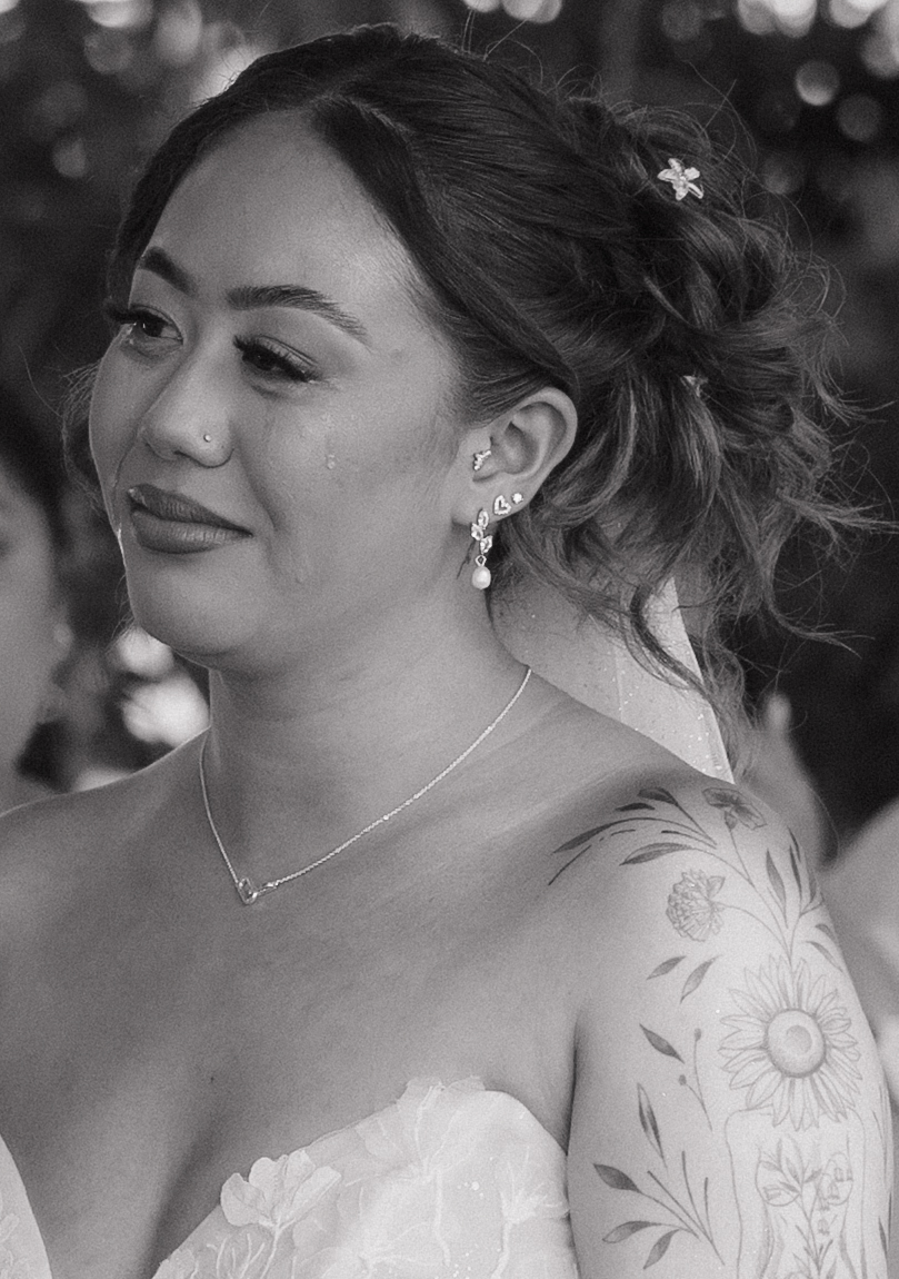 A candid photo of a bride during her wedding ceremony with a tear rolling down her cheek