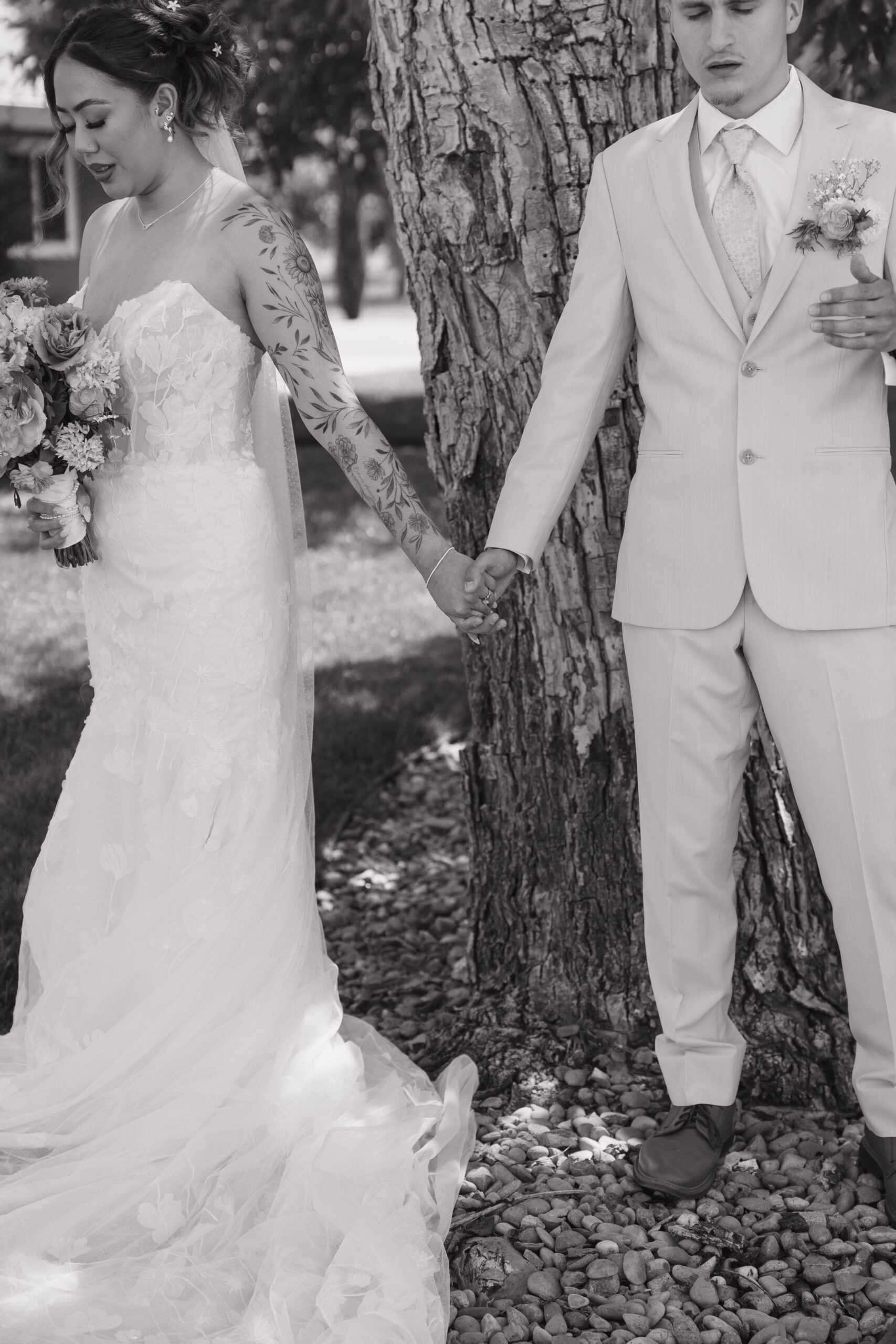 Bride and groom sharing a private first touch in a black and white wedding photo