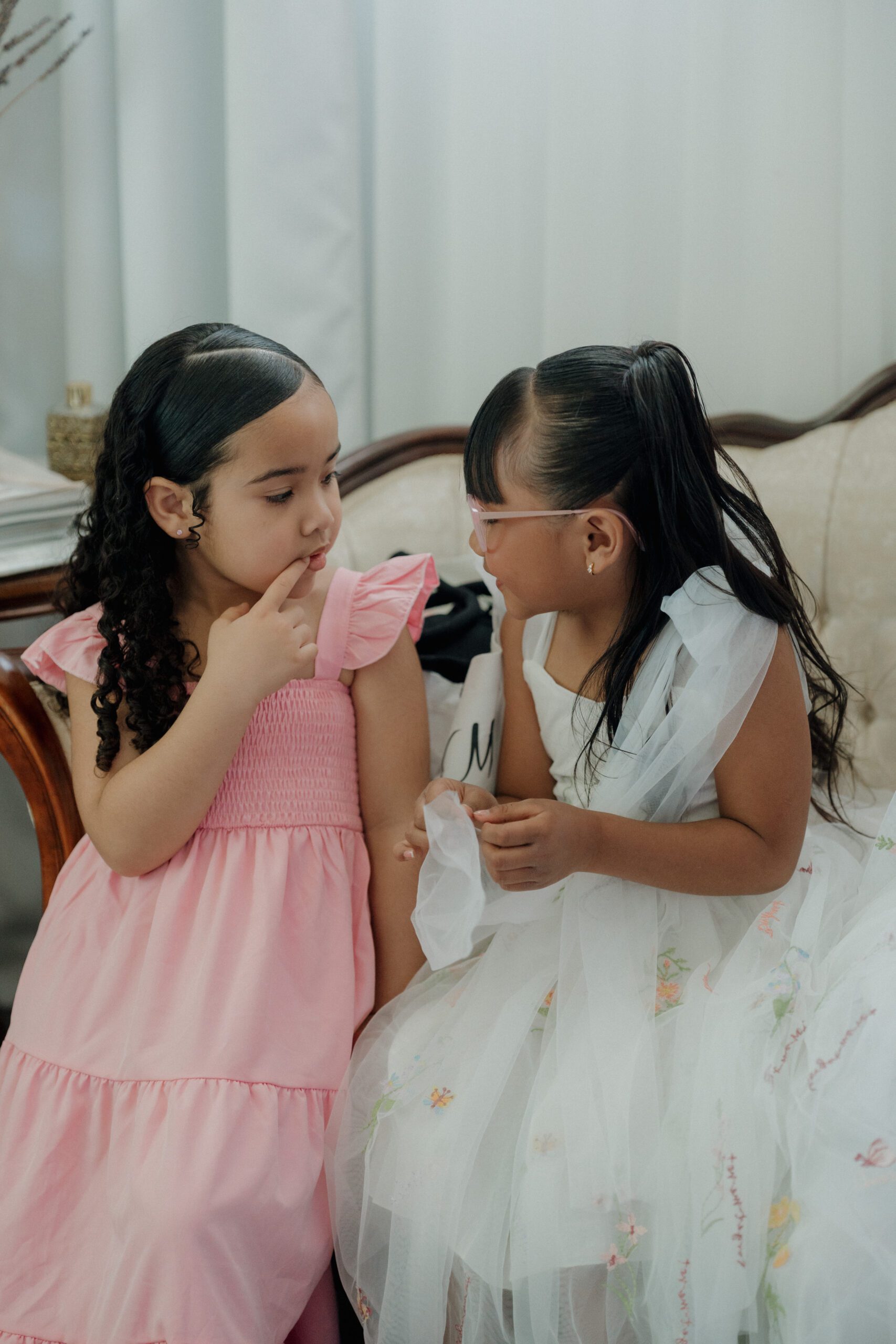 A candid photo of little girls talking during wedding getting ready photos