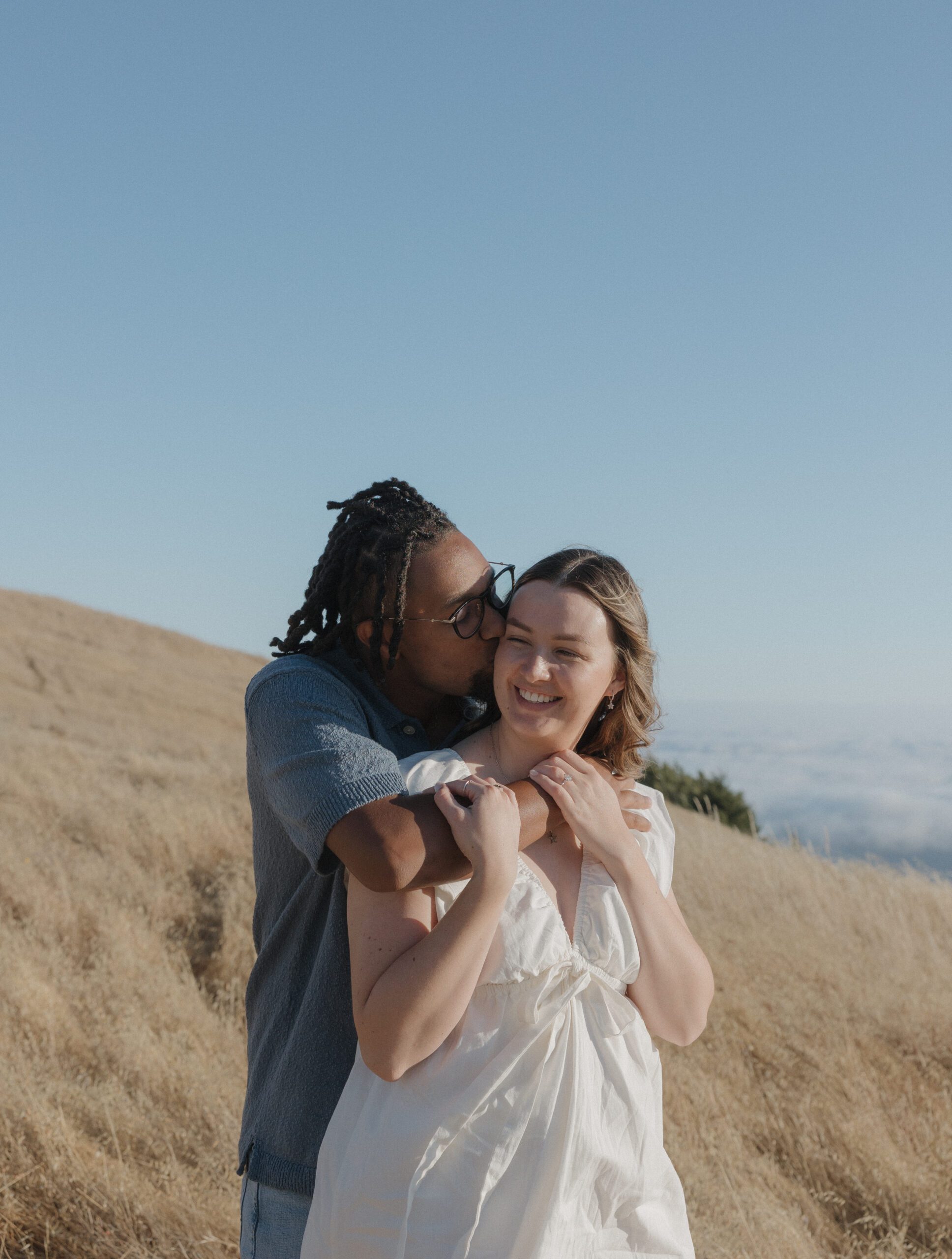 A man kissing his fiancee on the cheek