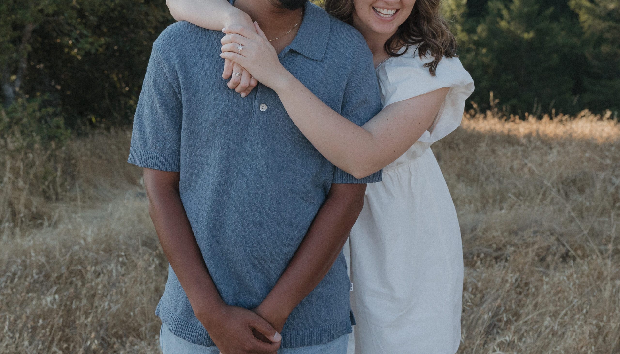 A girl hugging her fiancé from behind during engagement photos at Mt. Tamalpais, showing off their engagement photoshoot outfits