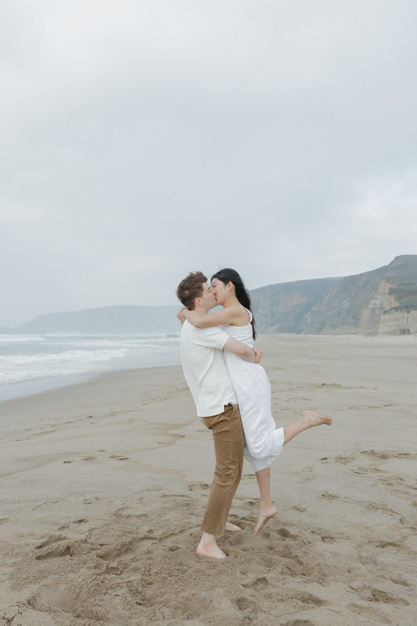A man holding his fiancee for engagement photo pose