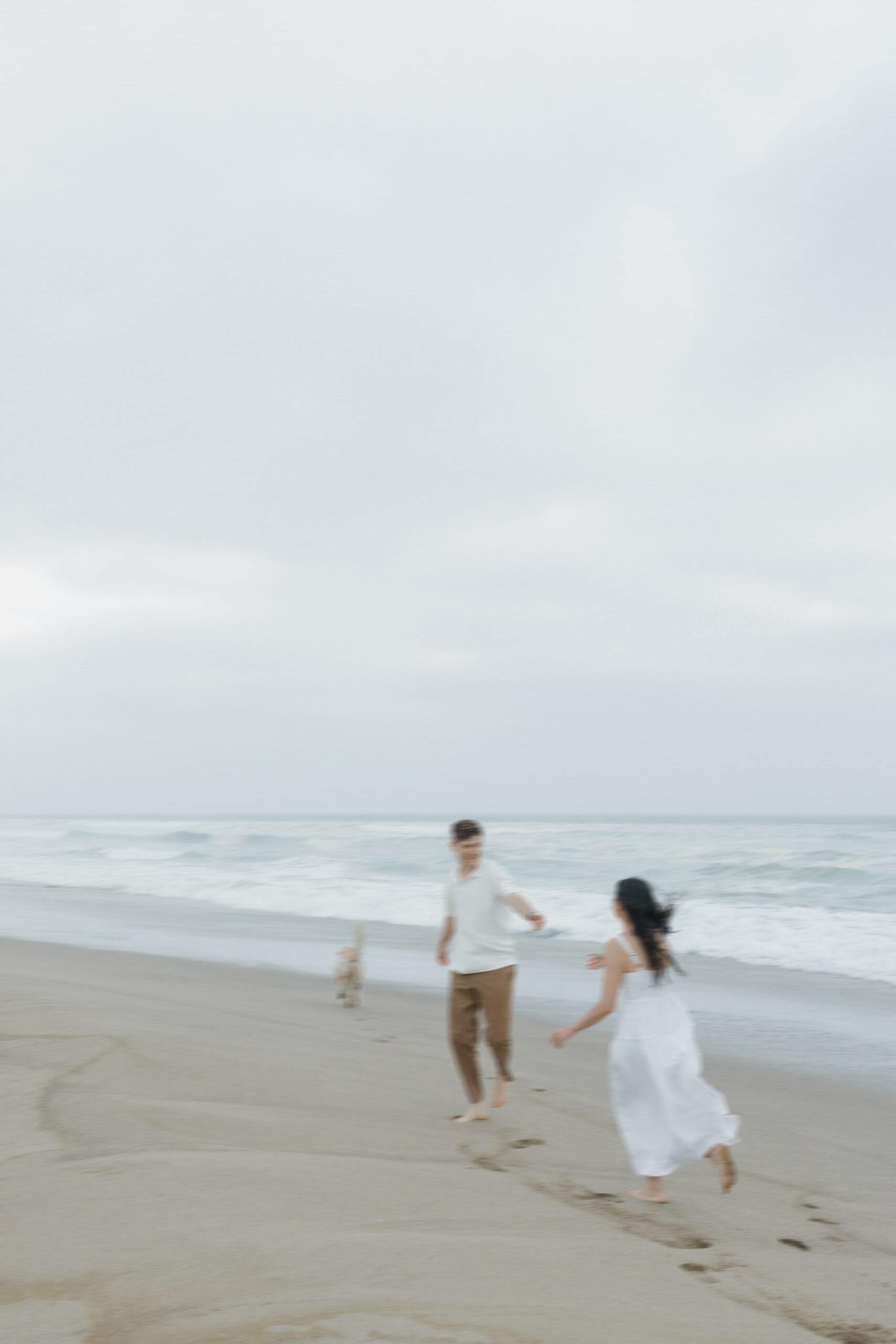 Blurry engagement photo of couple running on the beach
