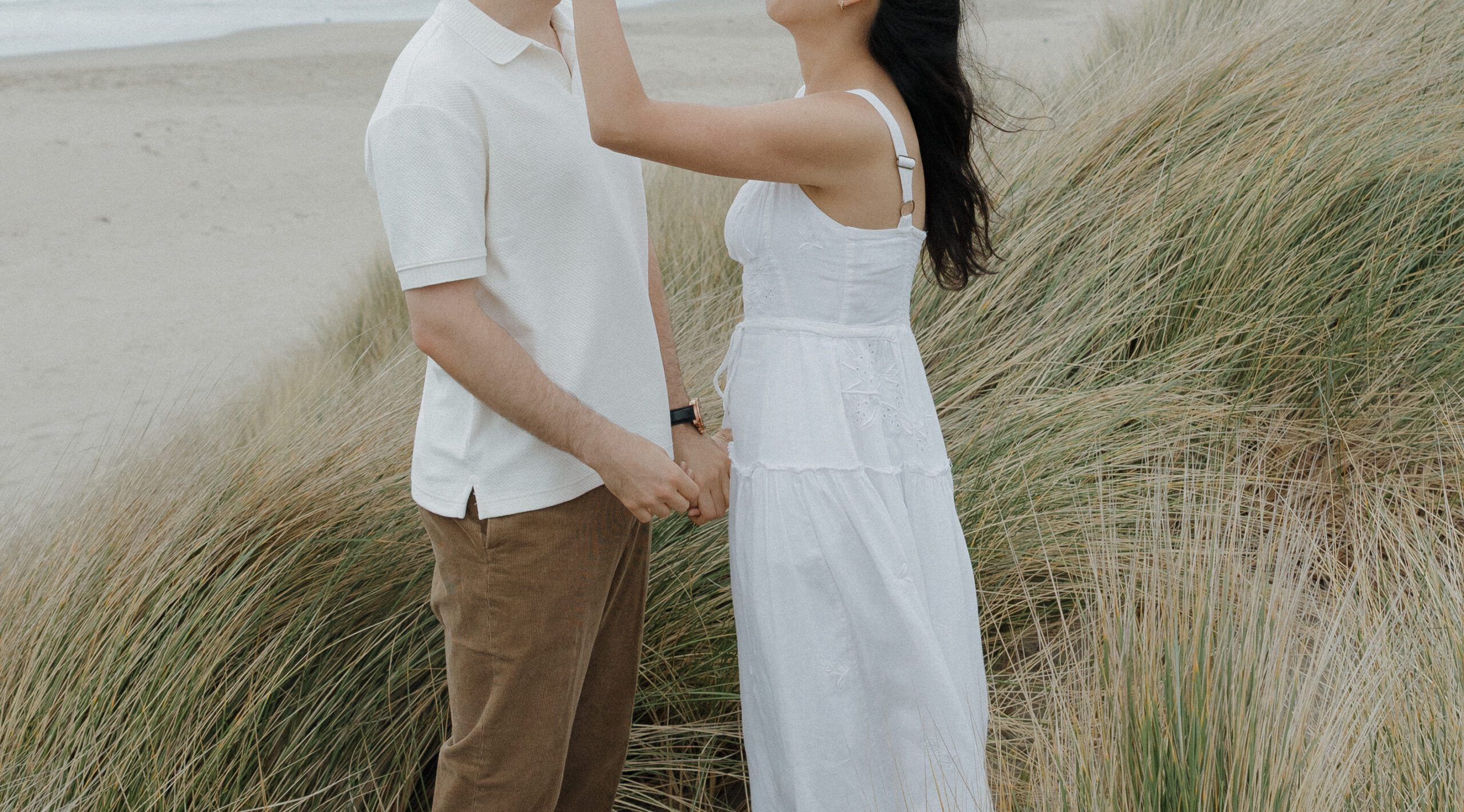 Candid engagement photo of girl fixing her fiancé's hair