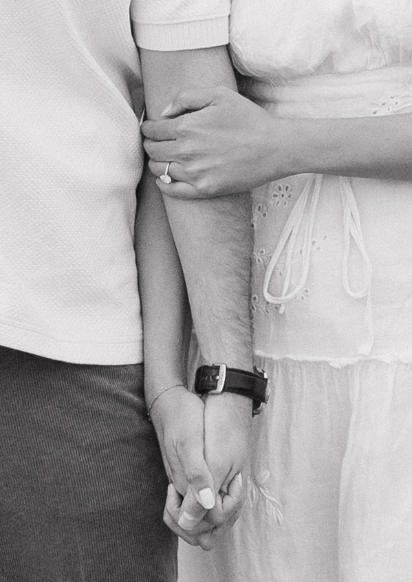 Black and white engagement photo showing off the ring