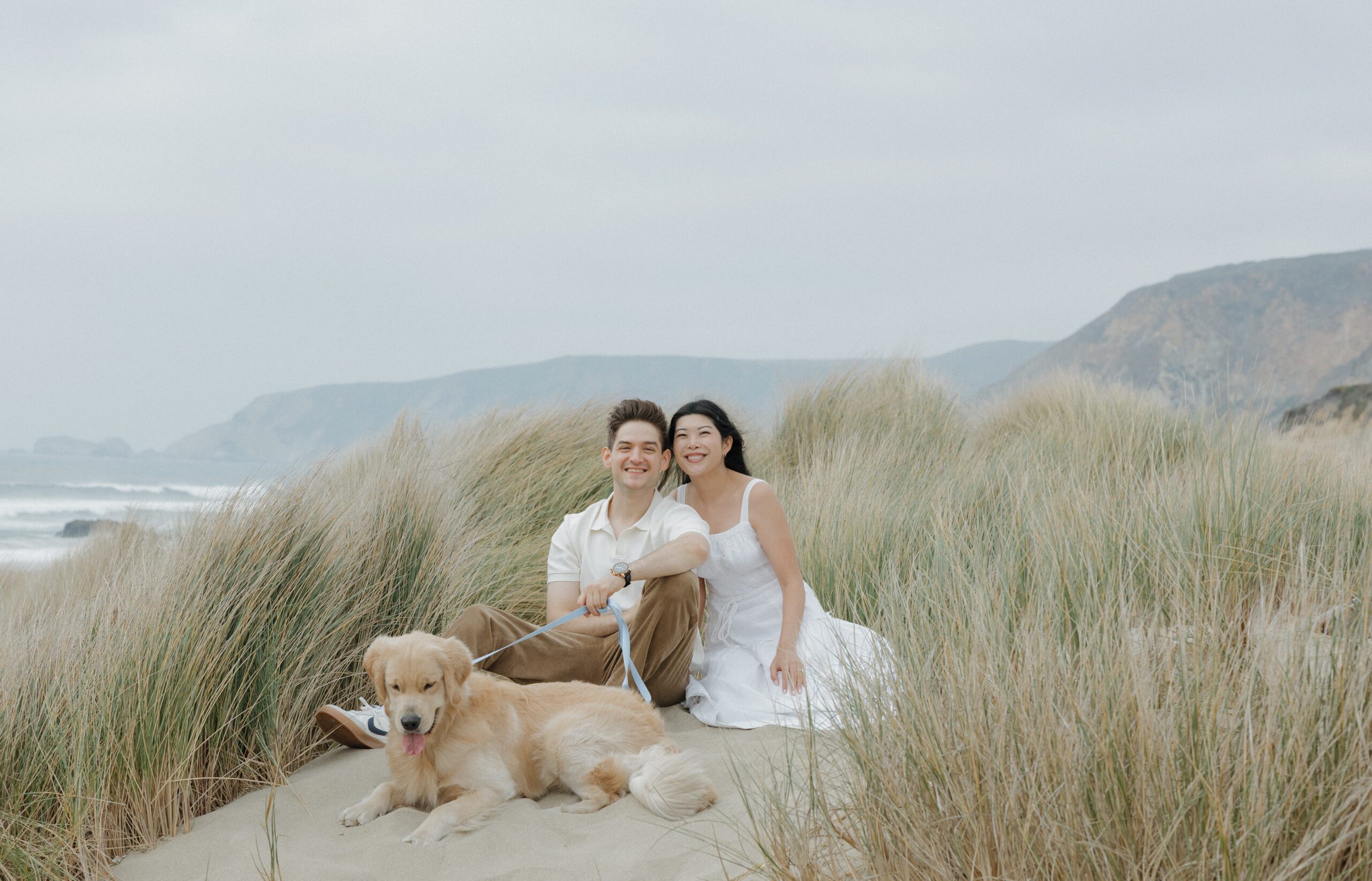 A couple sitting on the beach during engagement photos