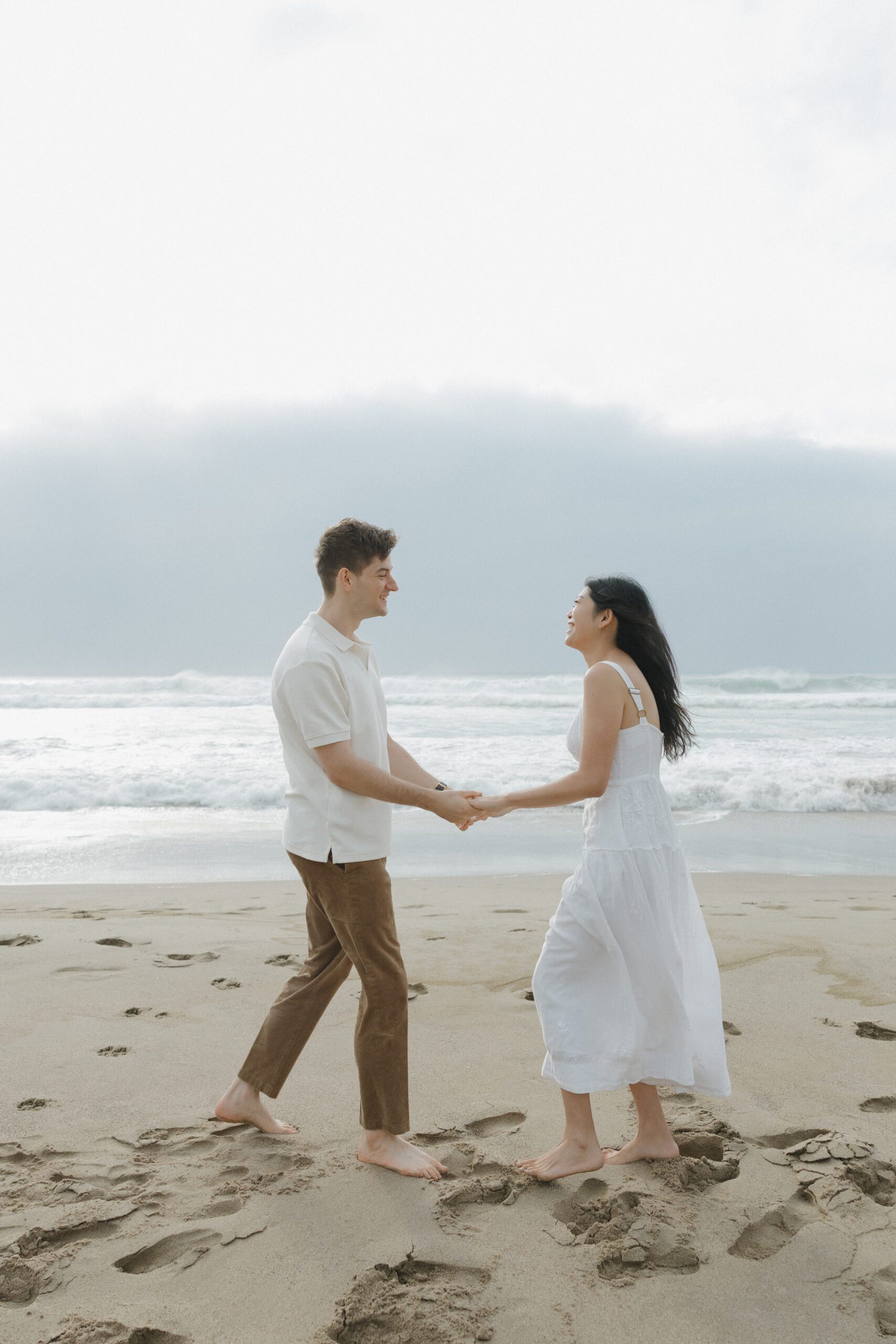 Couple dancing on the beach during engagement photos