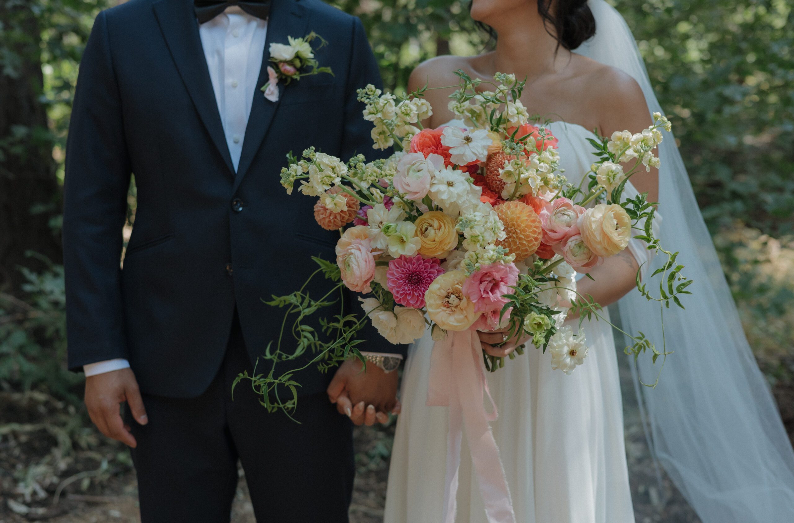 An editorial wedding photo of a bride and groom that shows off the bride's wedding bouquet