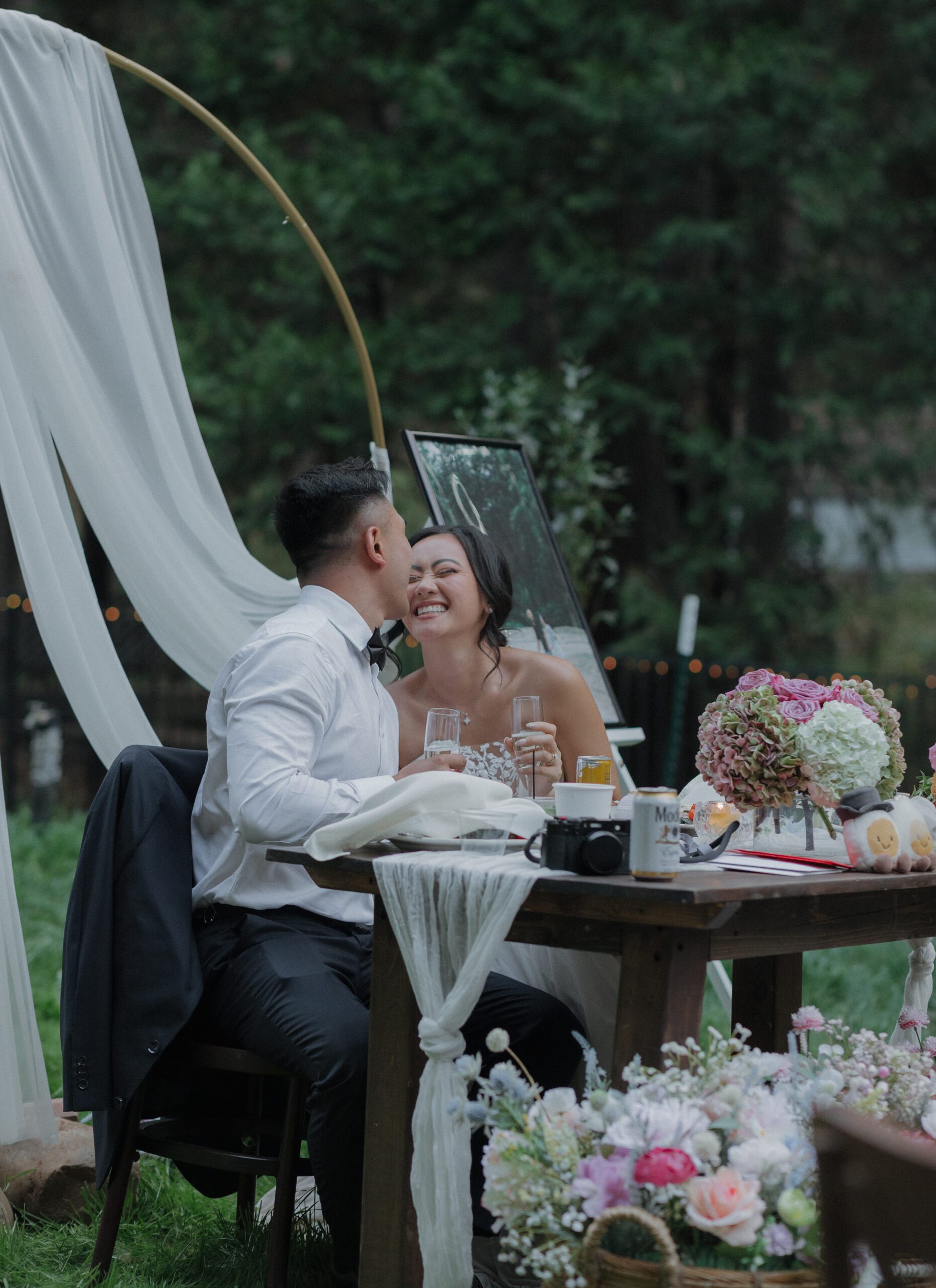 A couple laughing at their wedding sweetheart table