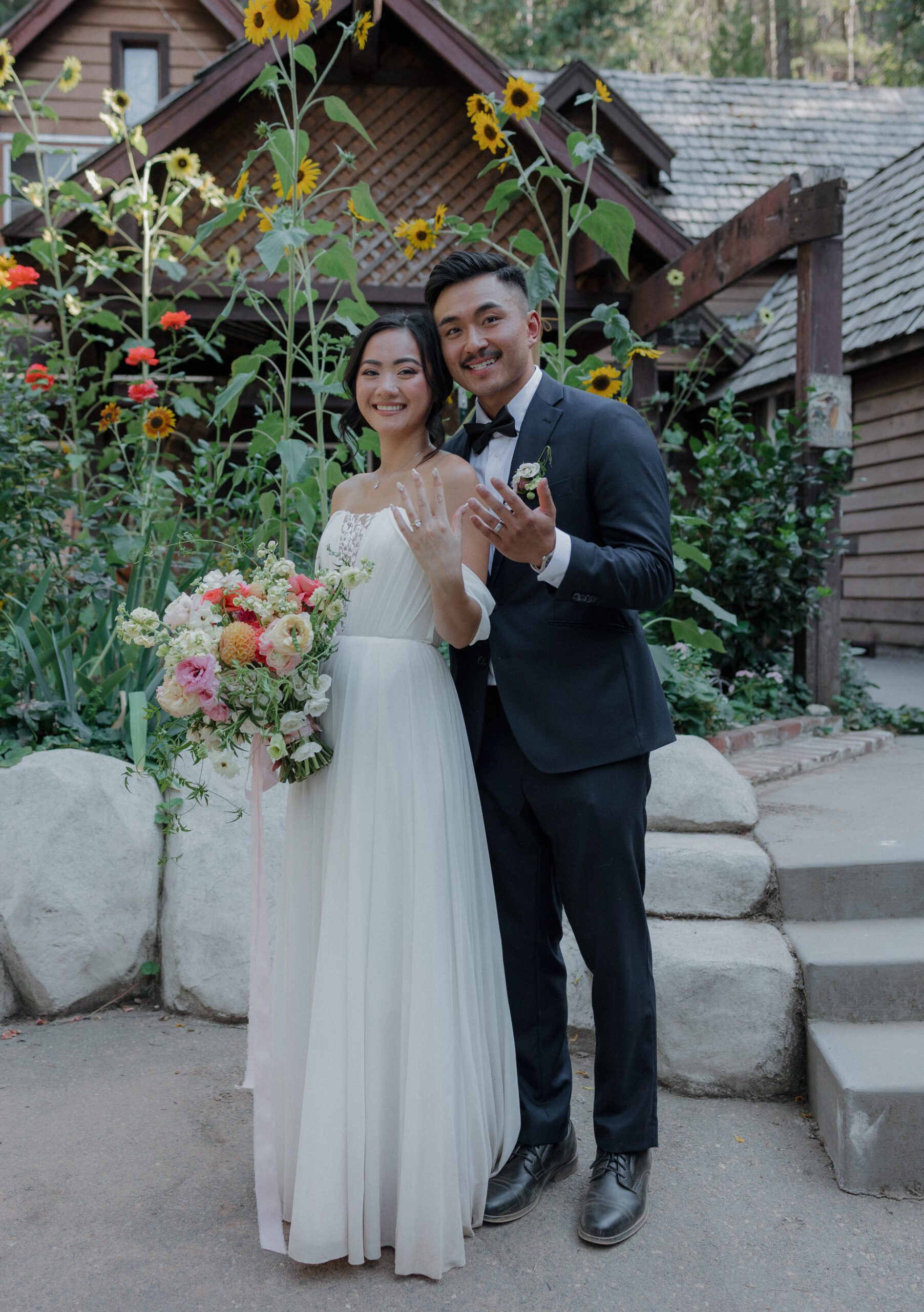 A bride and groom showing off their wedding rings