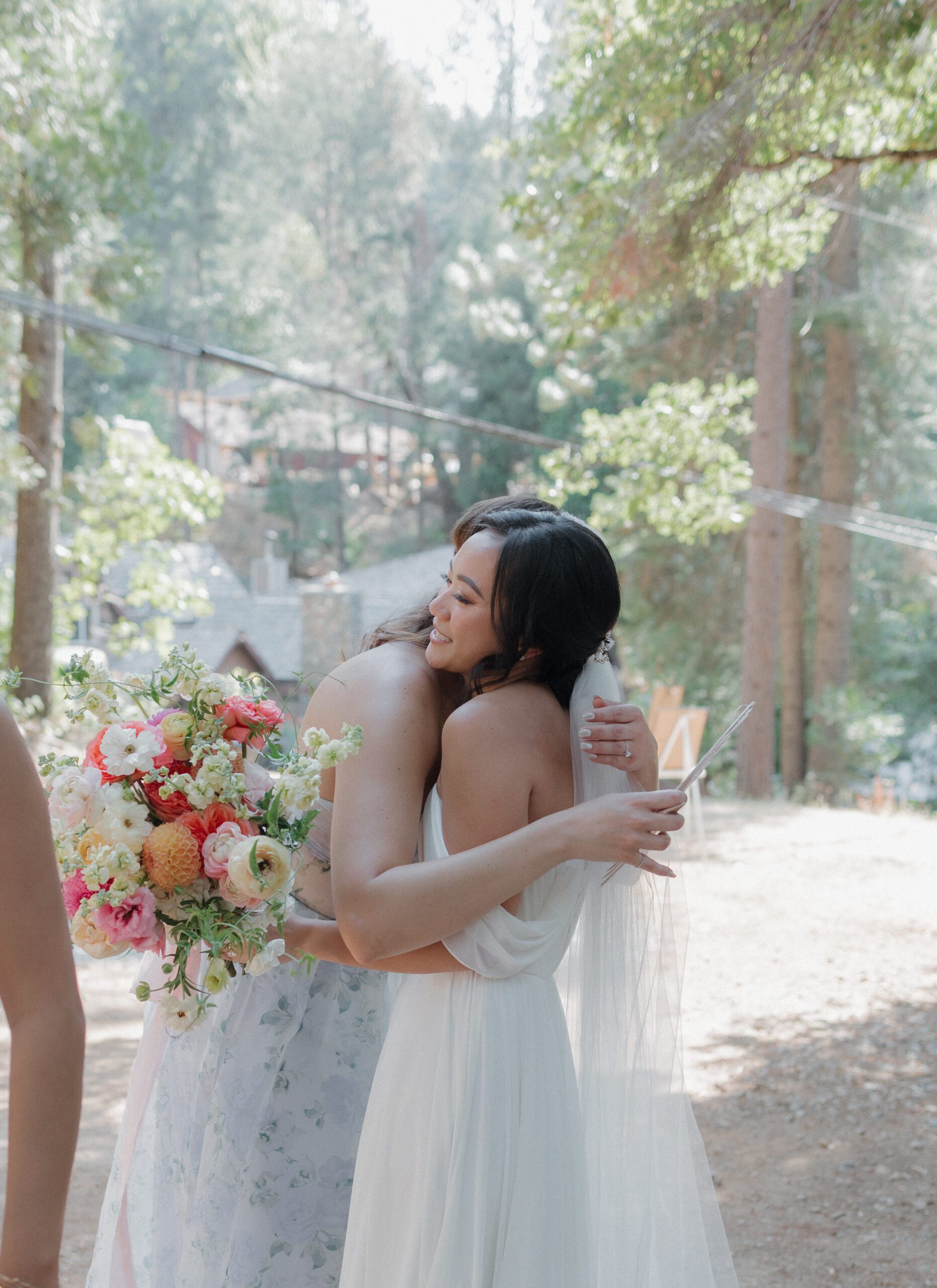 A bride hugging a wedding guest at an intimate wedding