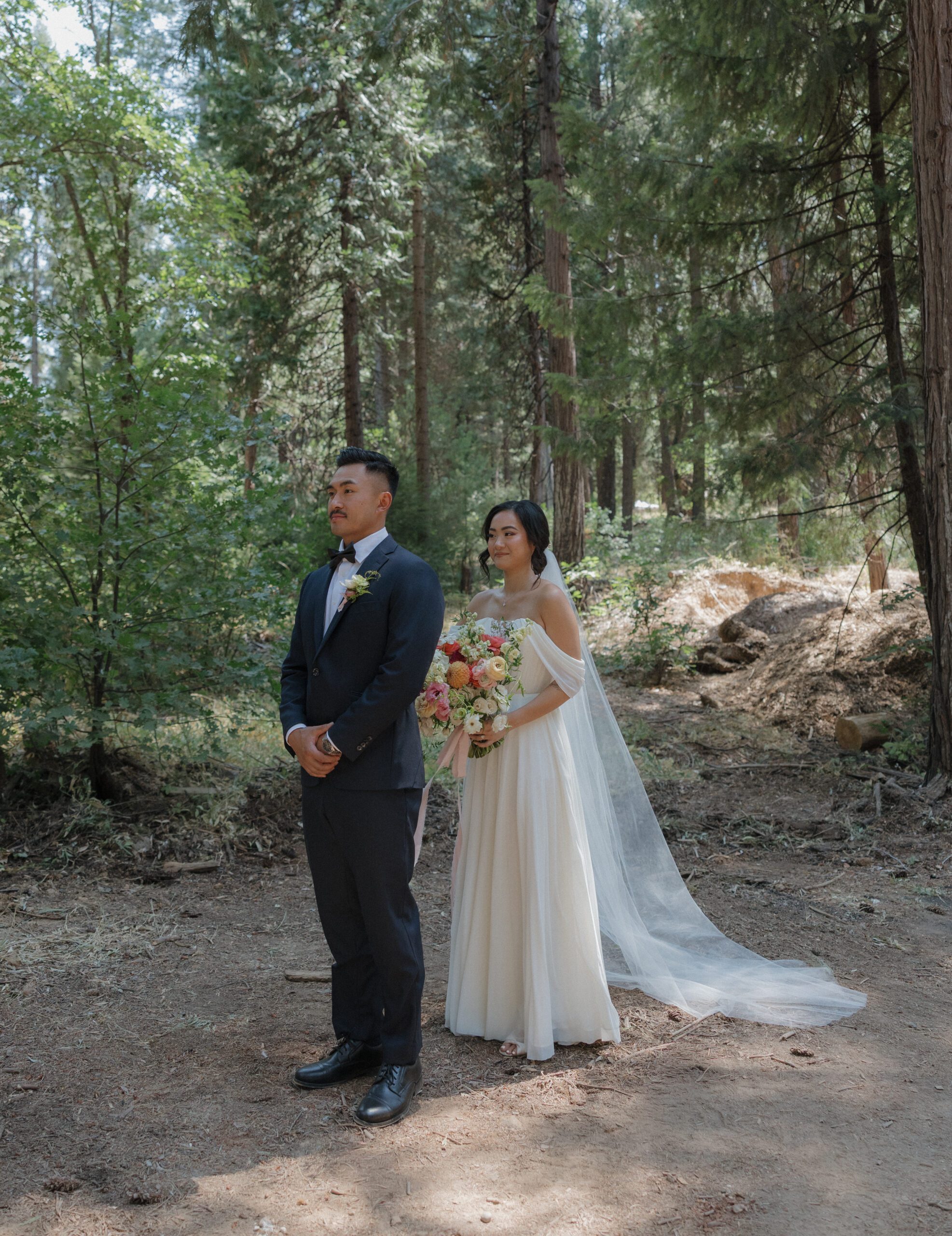 A bride standing behind a groom right before a first look