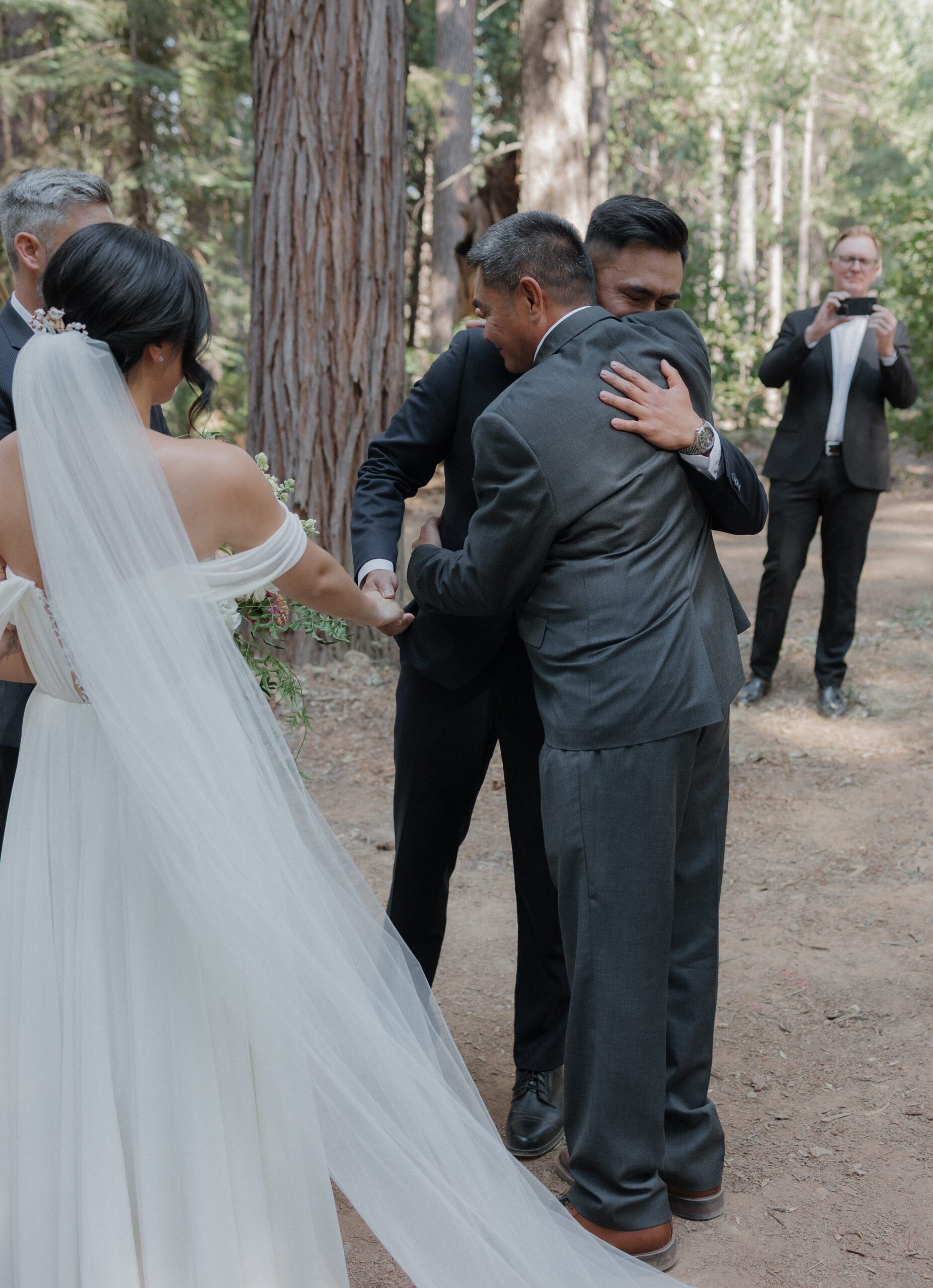 A groom hugging a family member at an intimate wedding