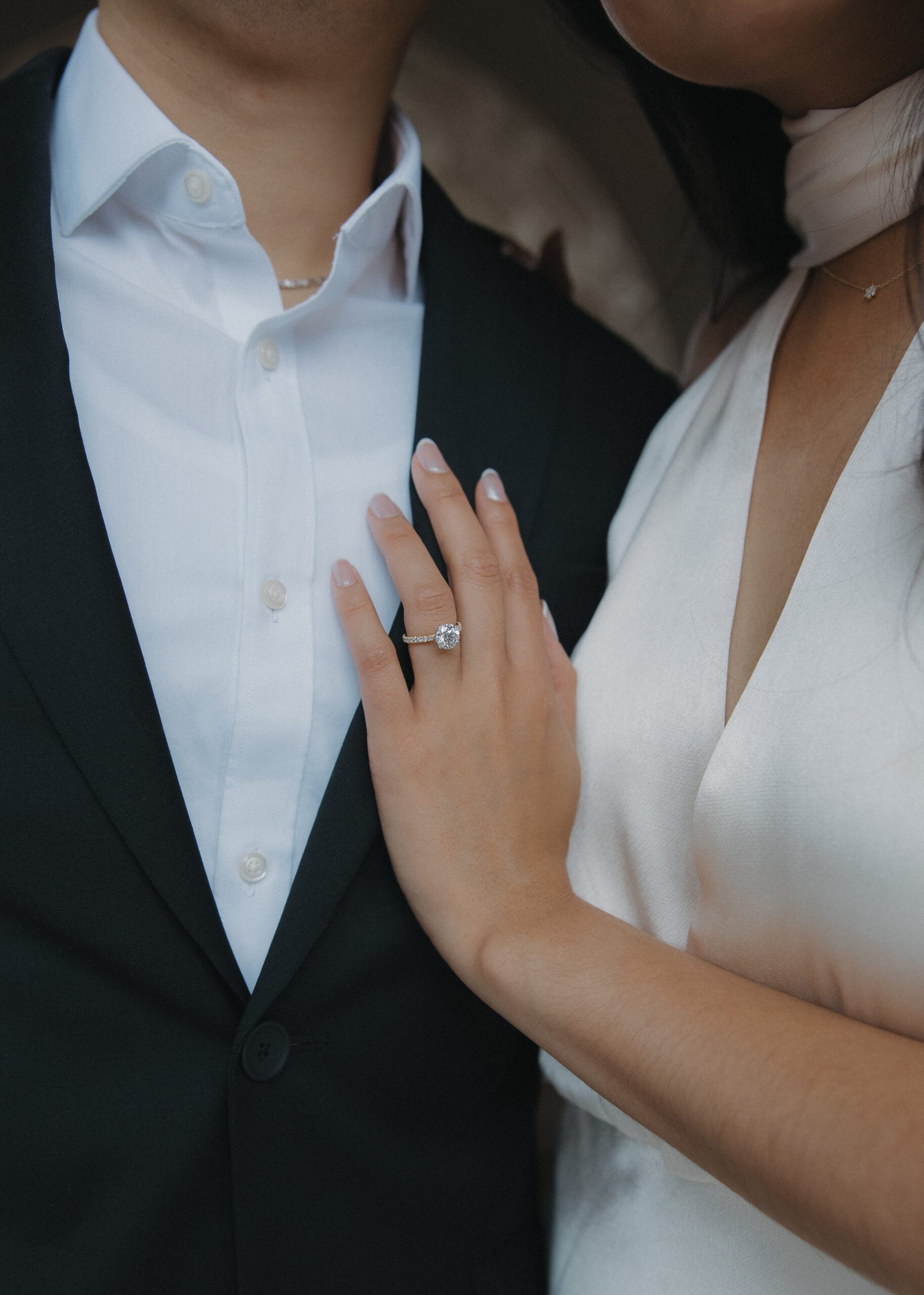 A woman putting her hand on her fiancé's chest during their engagement photoshoot