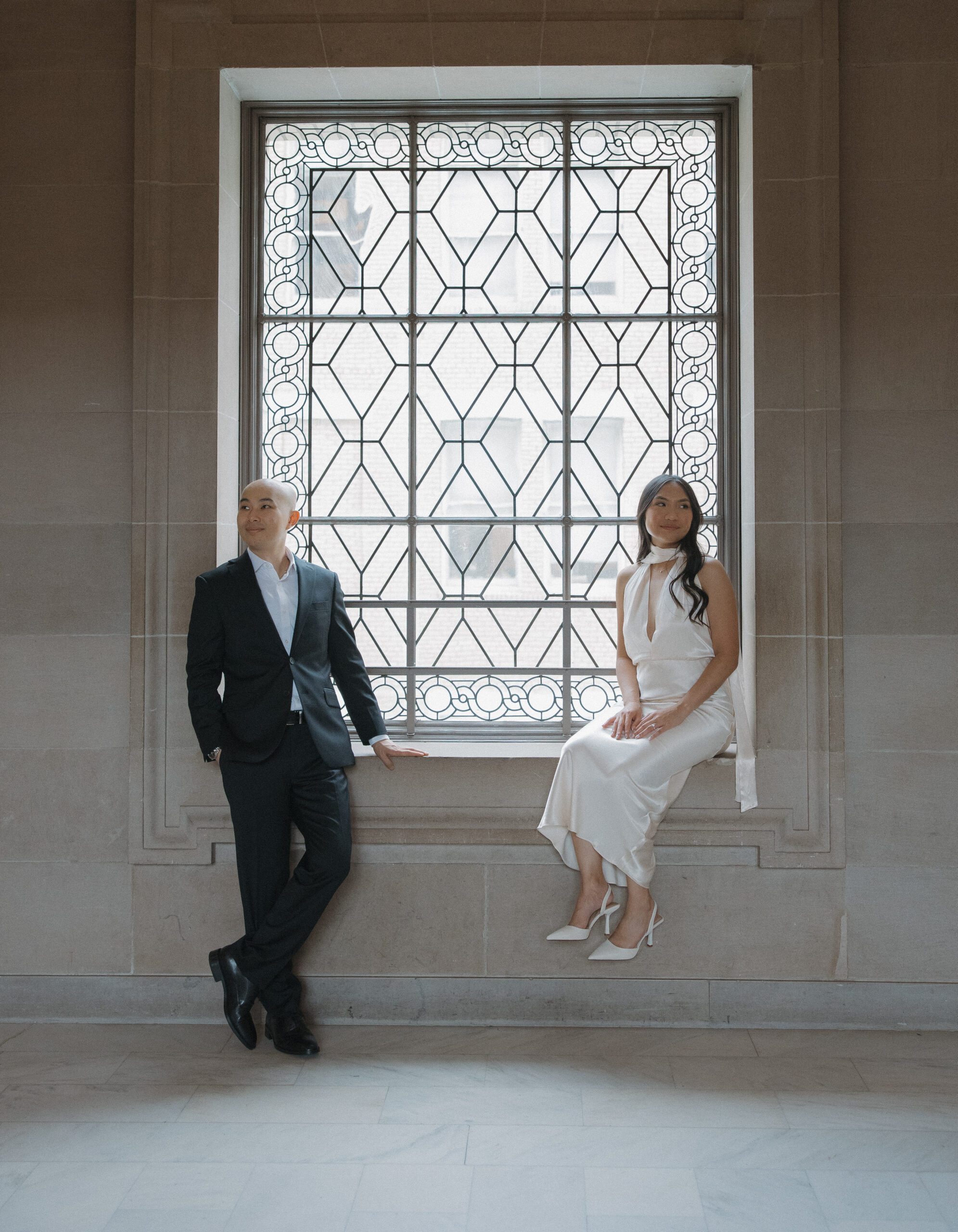 San Francisco City Hall photos on the fourth floor with a couple sitting on opposite sides of a window