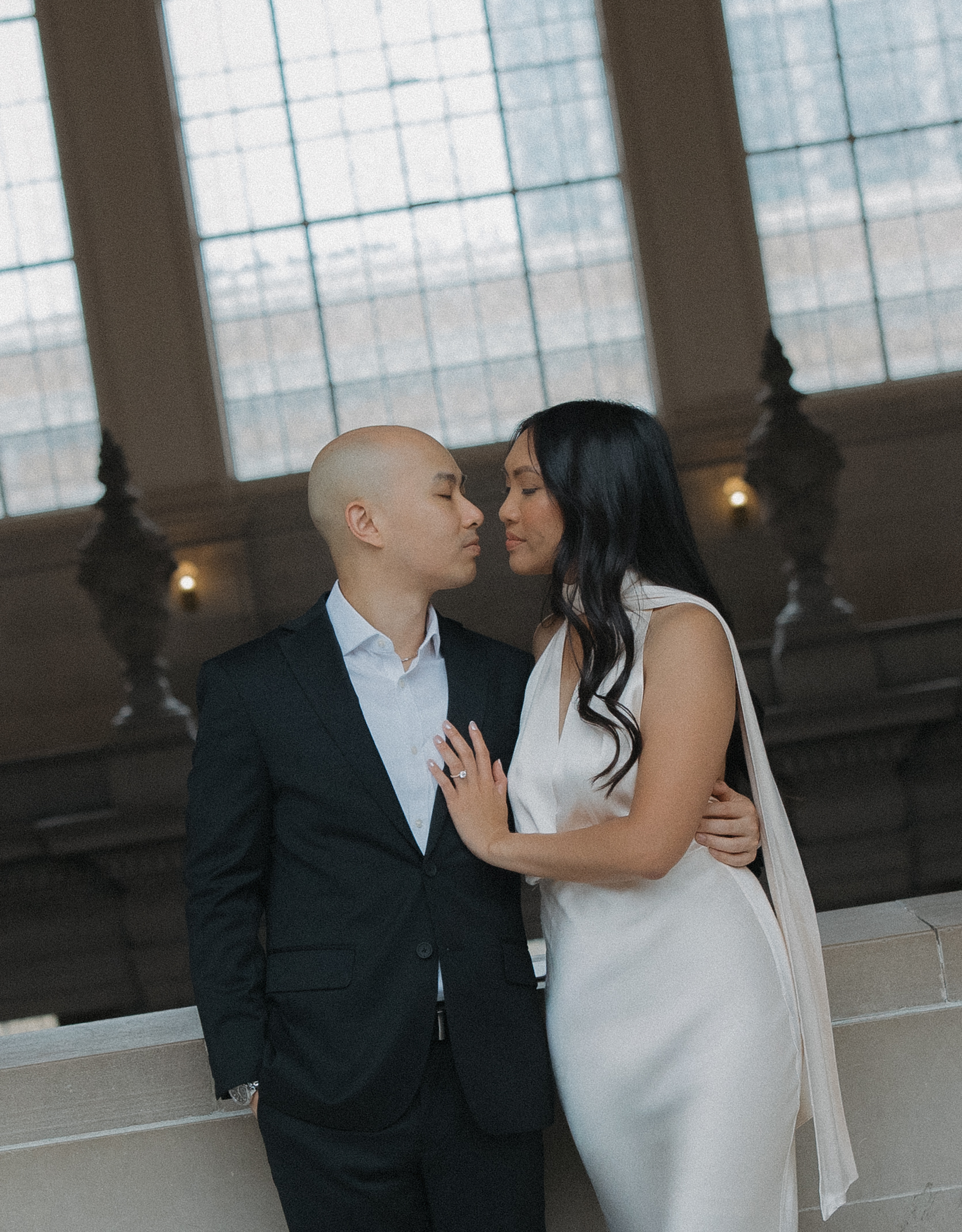 A couple leaning in for a kiss on the fourth floor of San Francisco City Hall for their engagement photoshoot