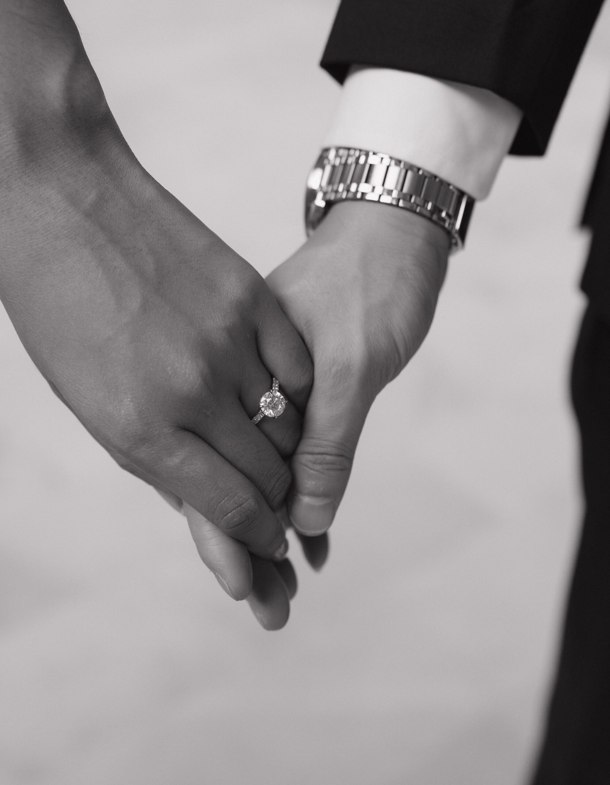 A couple holding hands in a black and white engagement photo