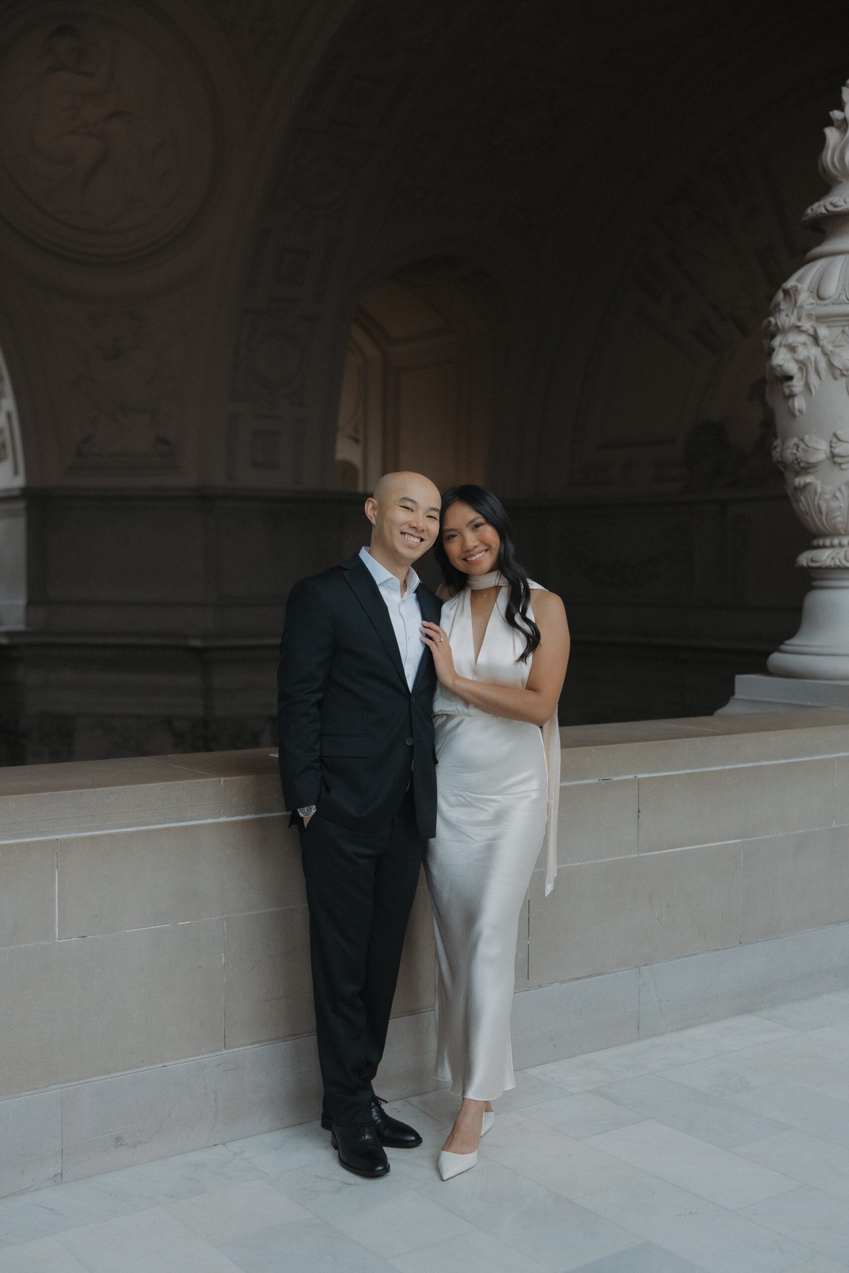 A couple posing for photos at San Francisco City Hall