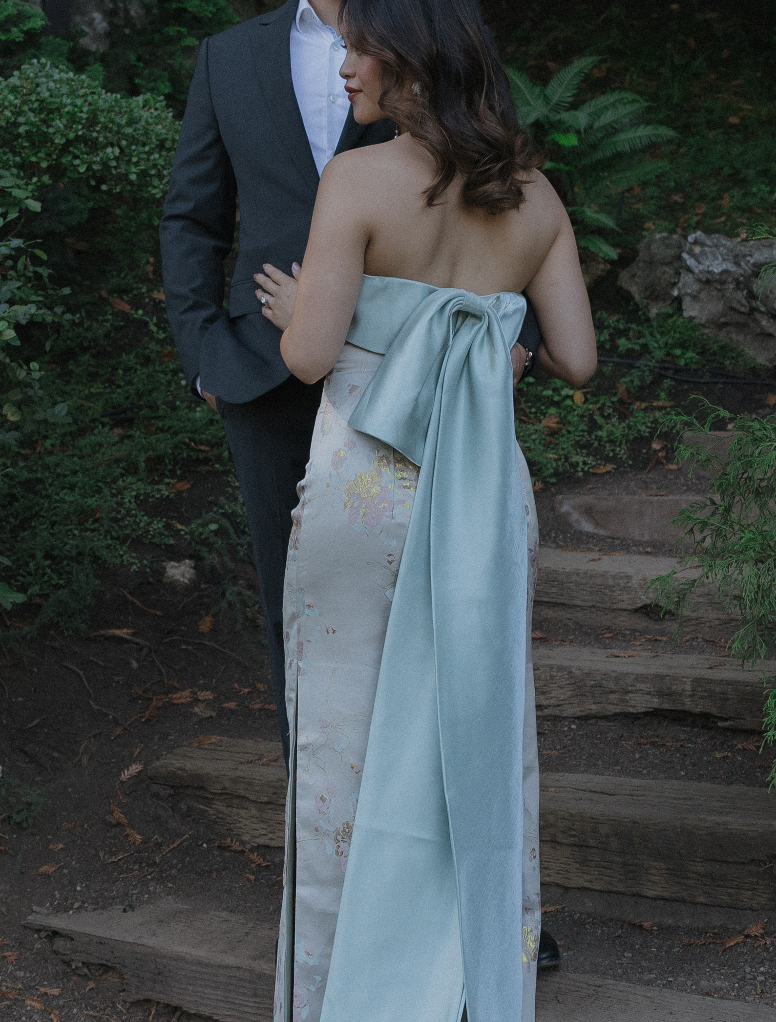 A woman wearing her engagement photoshoot dress that has a bow on the back