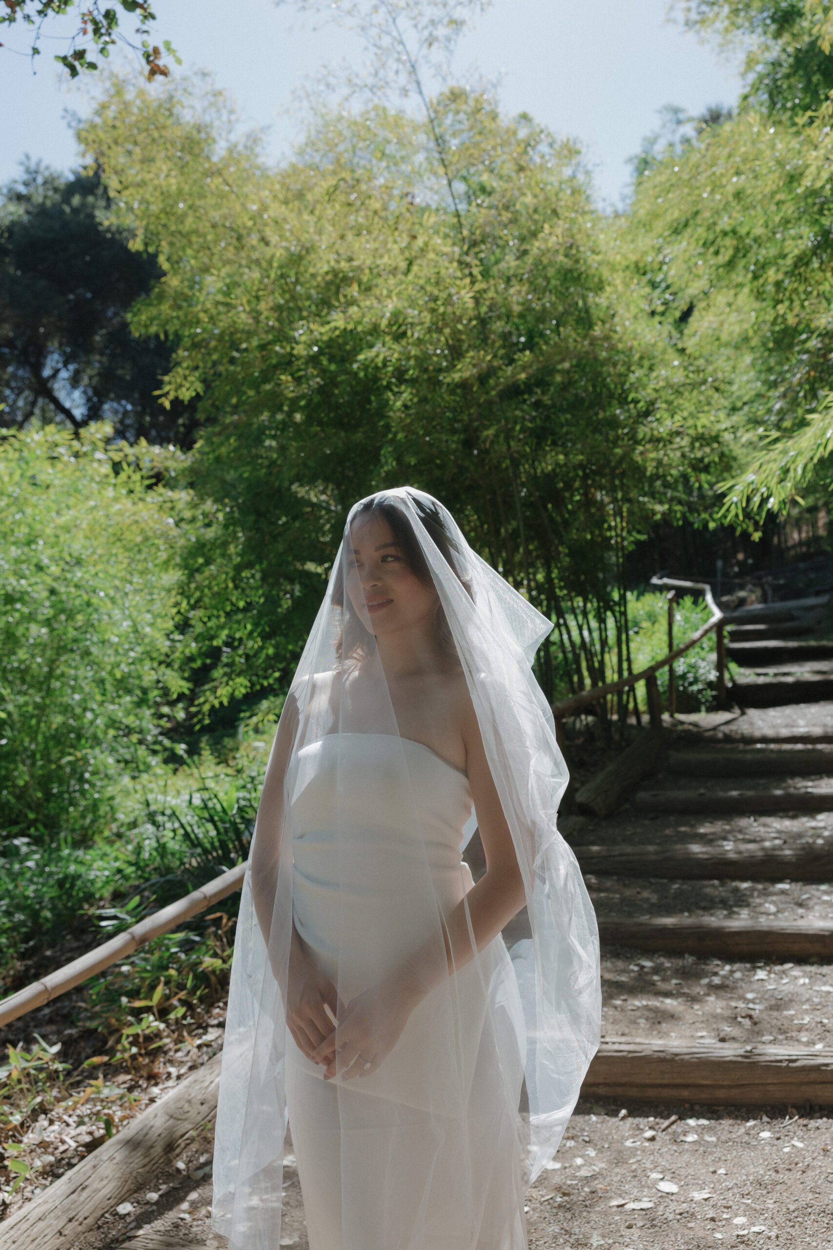 A woman wearing a veil during her engagement photos at Hakone Estate and Gardens