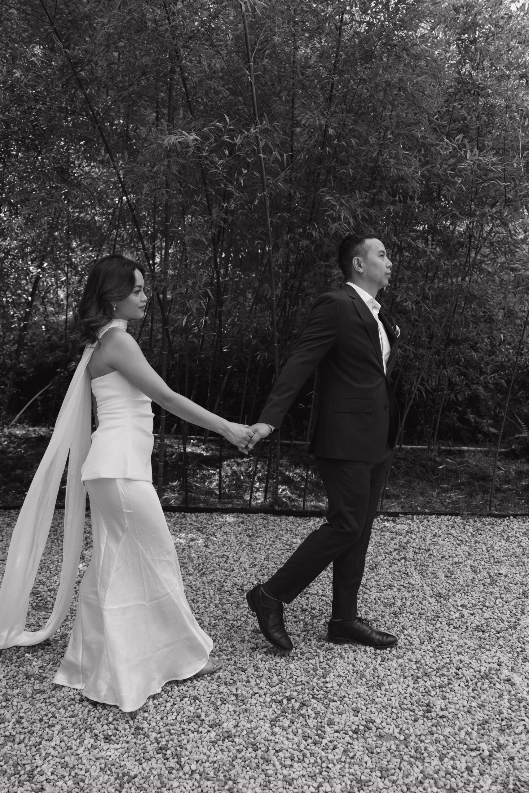 A couple walking through the bamboo garden in a black and white photo at Hakone estate and gardens