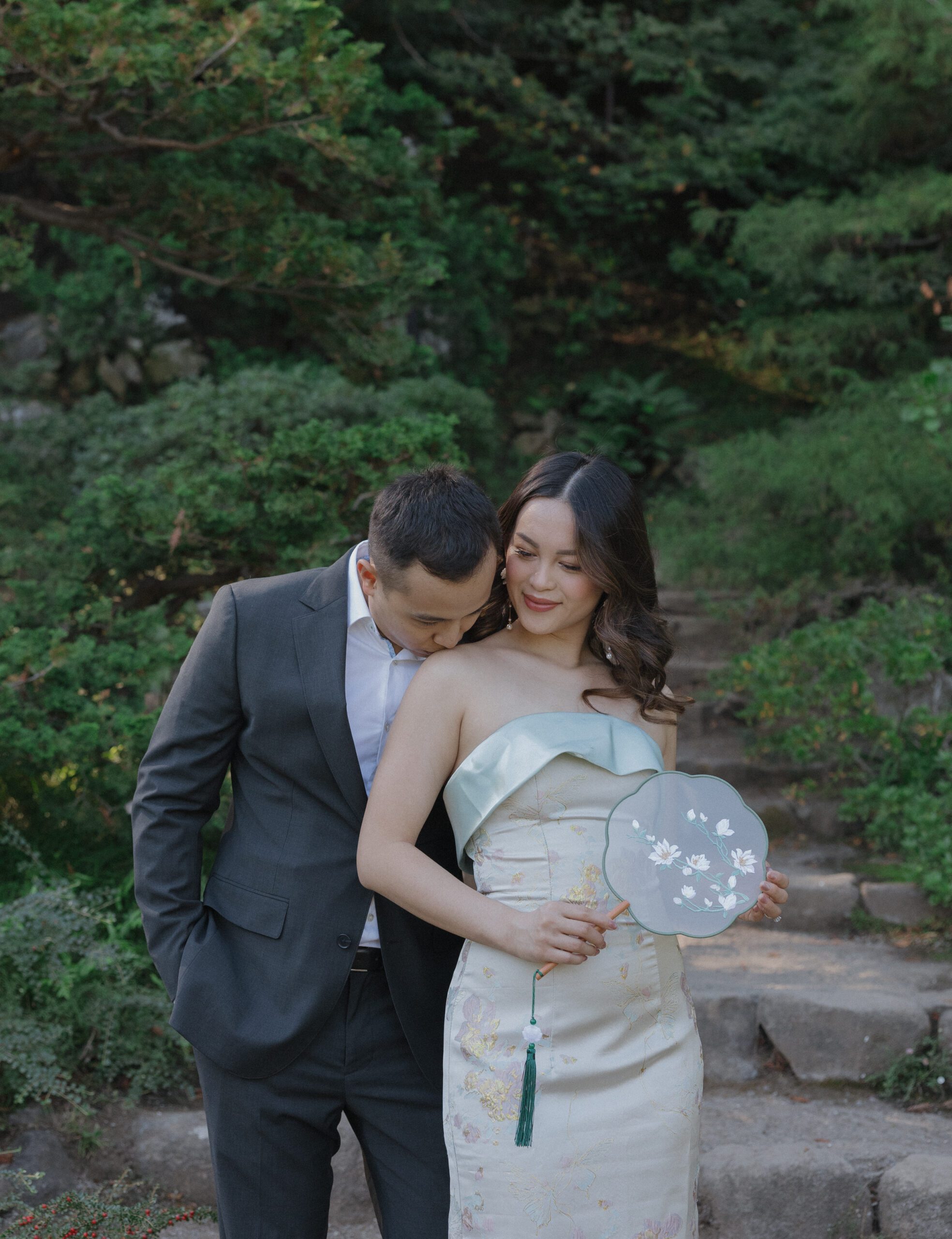 A man kissing his fiancee on the shoulder during engagement photos