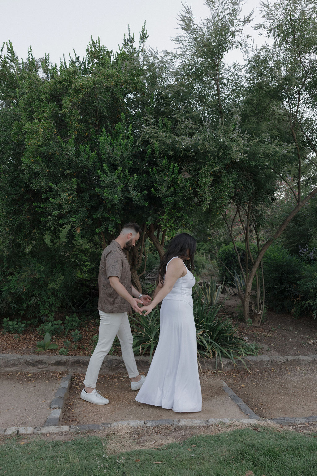 A couple walking through William Land Park in Sacramento for engagement photos