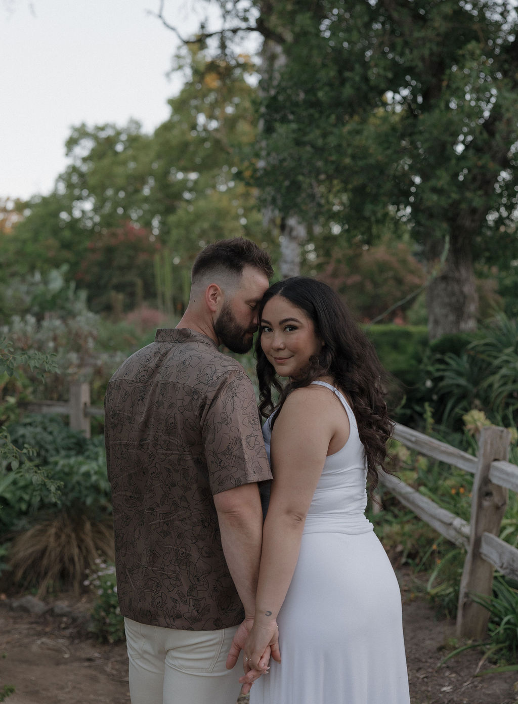A couple posing William Land Park in Sacramento for engagement photos
