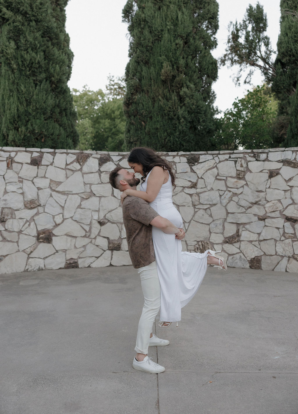 A man lifting up his fiancee for engagement photos