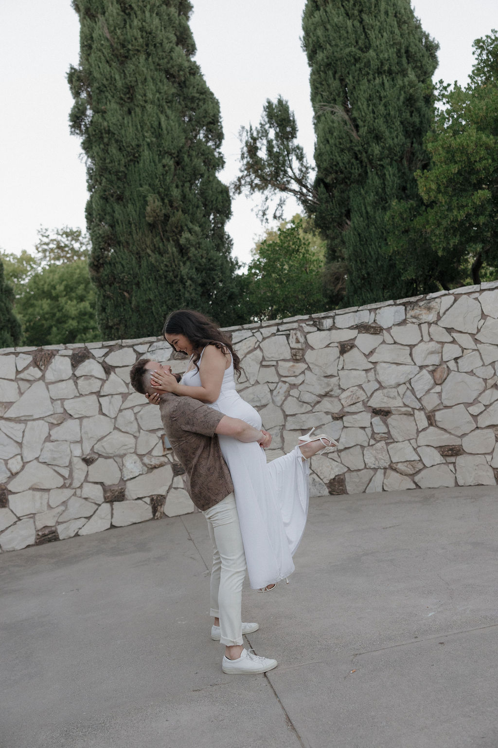 A couple posing for photos at their engagement photo location with the man holding his fiancee
