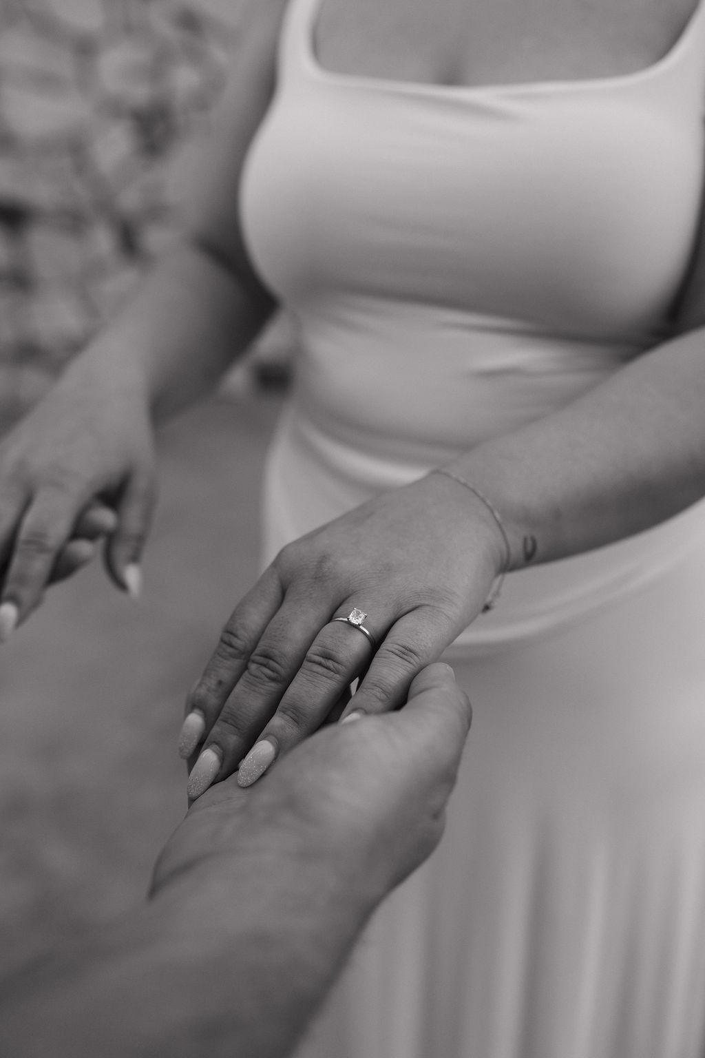 An up close photo showing a woman's engagement ring and engagement photo outfit