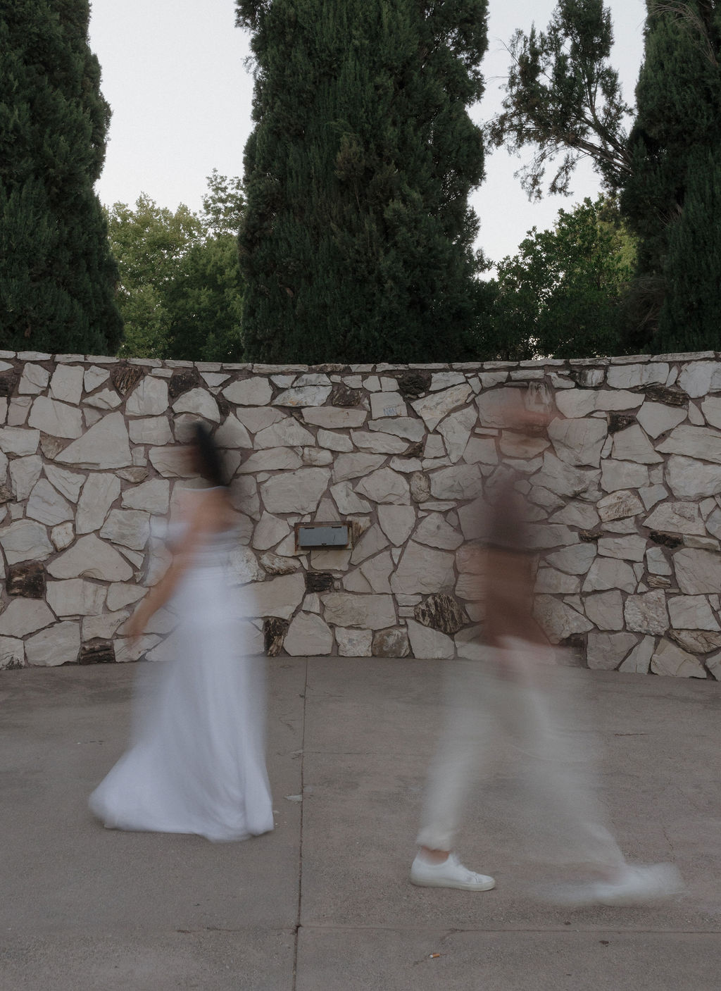 A blurry photo of a couple walking past each other for engagement photos at William Land Park