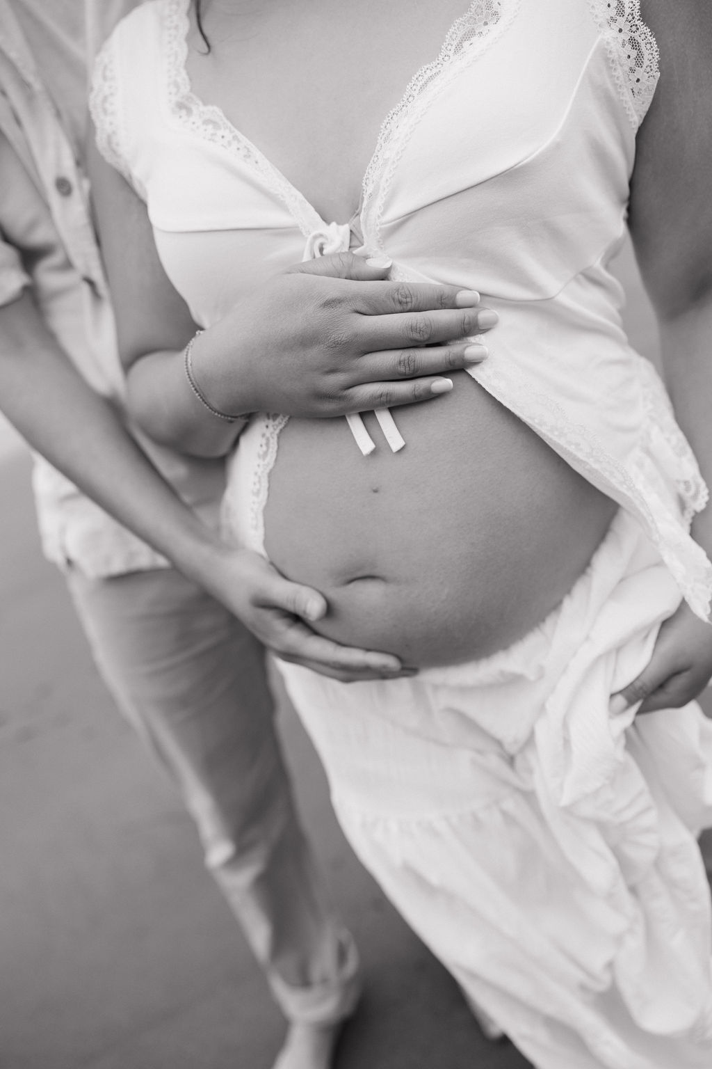 A woman holding her belly during beach maternity photos