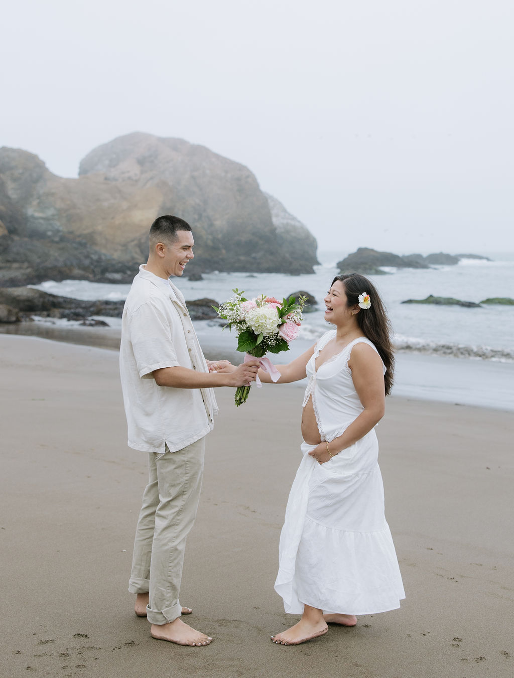 A man giving a woman flowers during her maternity photoshoot