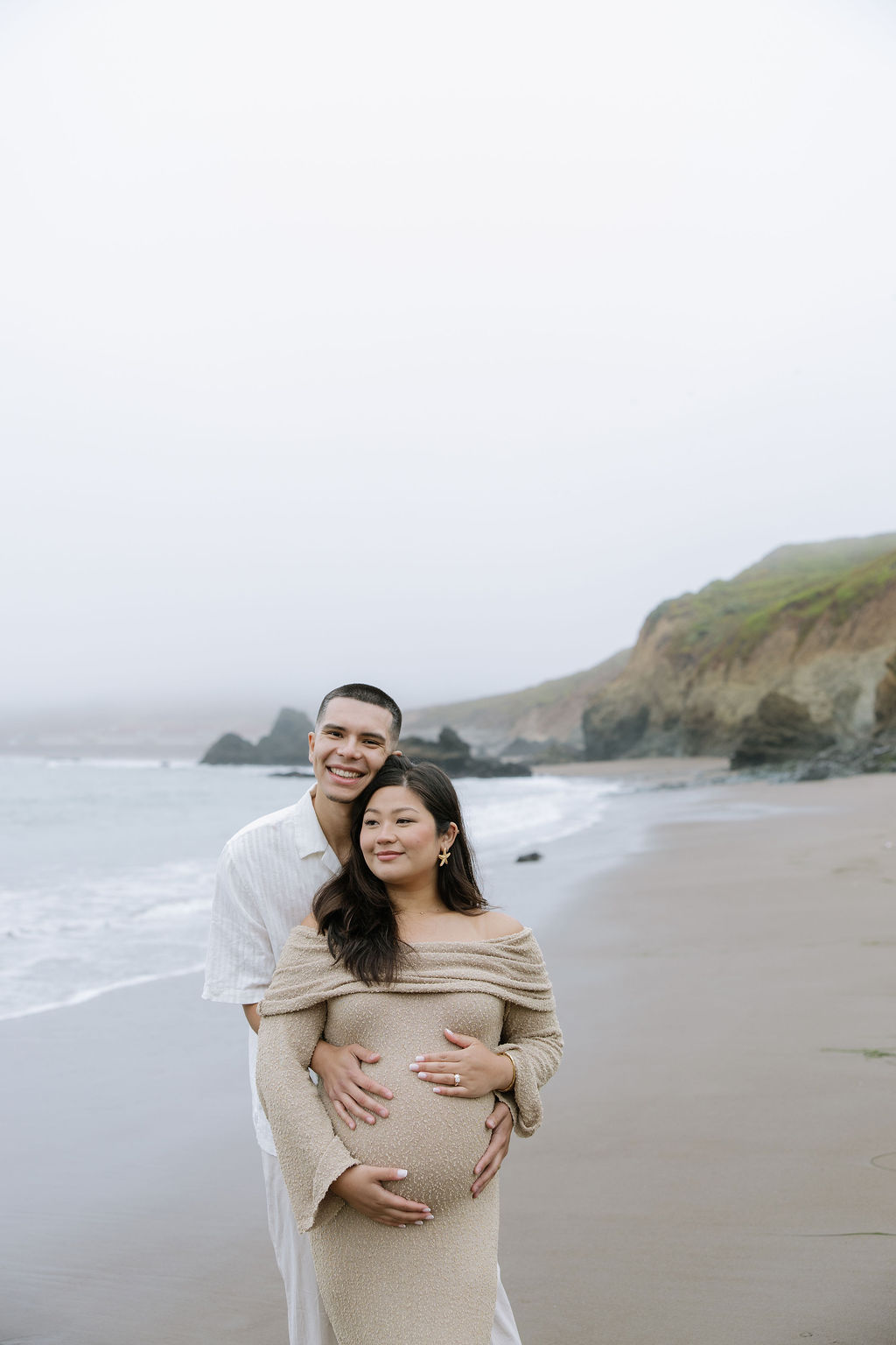 A couple hugging during beach maternity photos