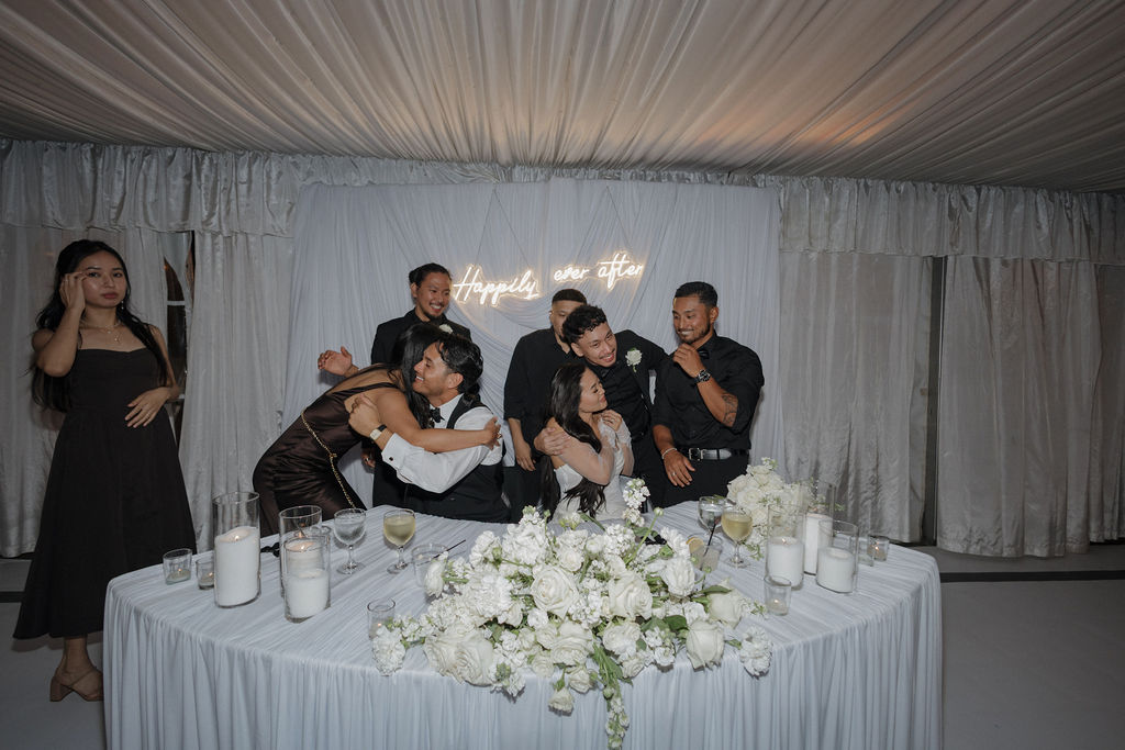 Wedding guests hugging the wedding couple at their sweetheart table