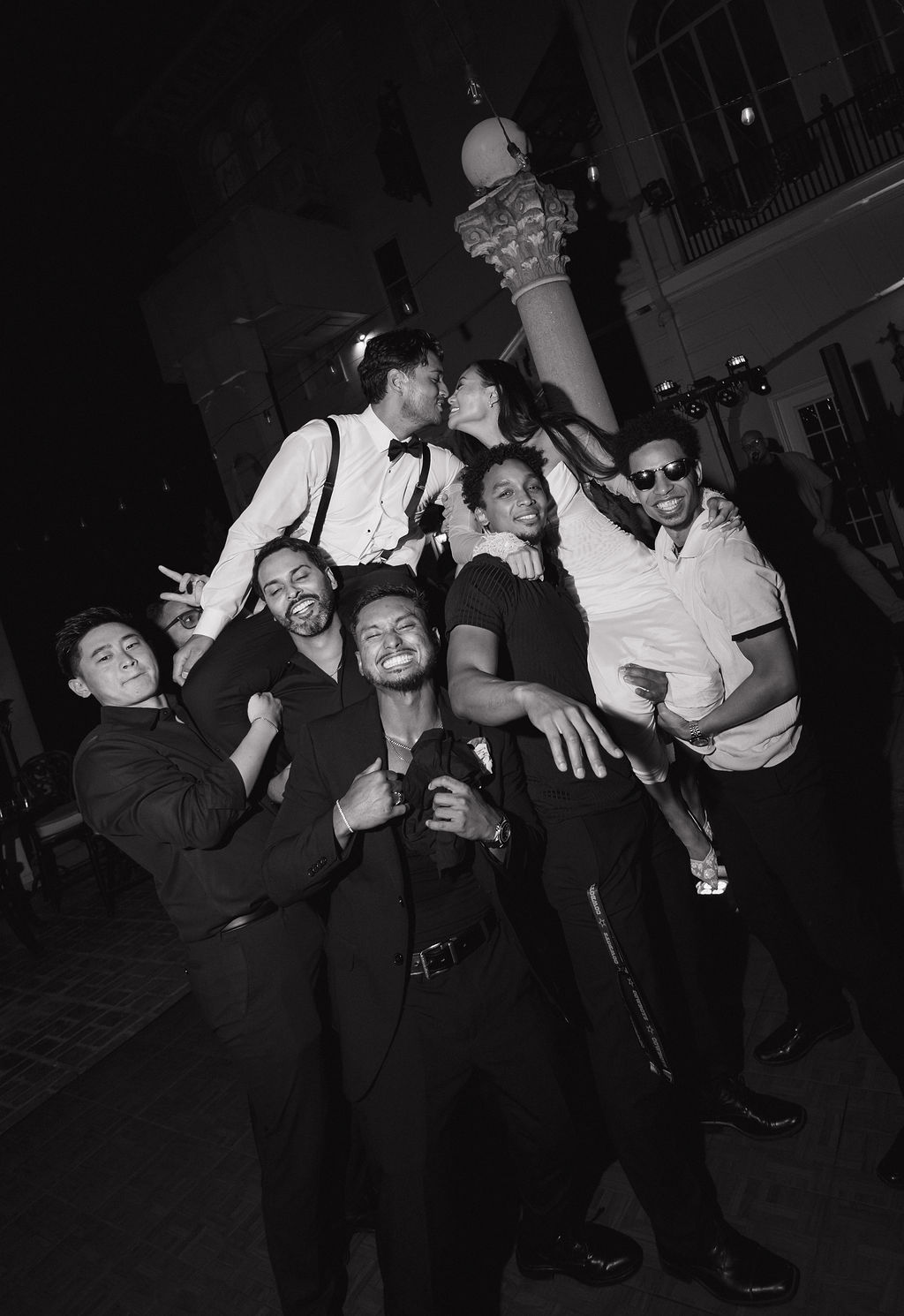 Wedding guests lifting up a couple on the dance floor 