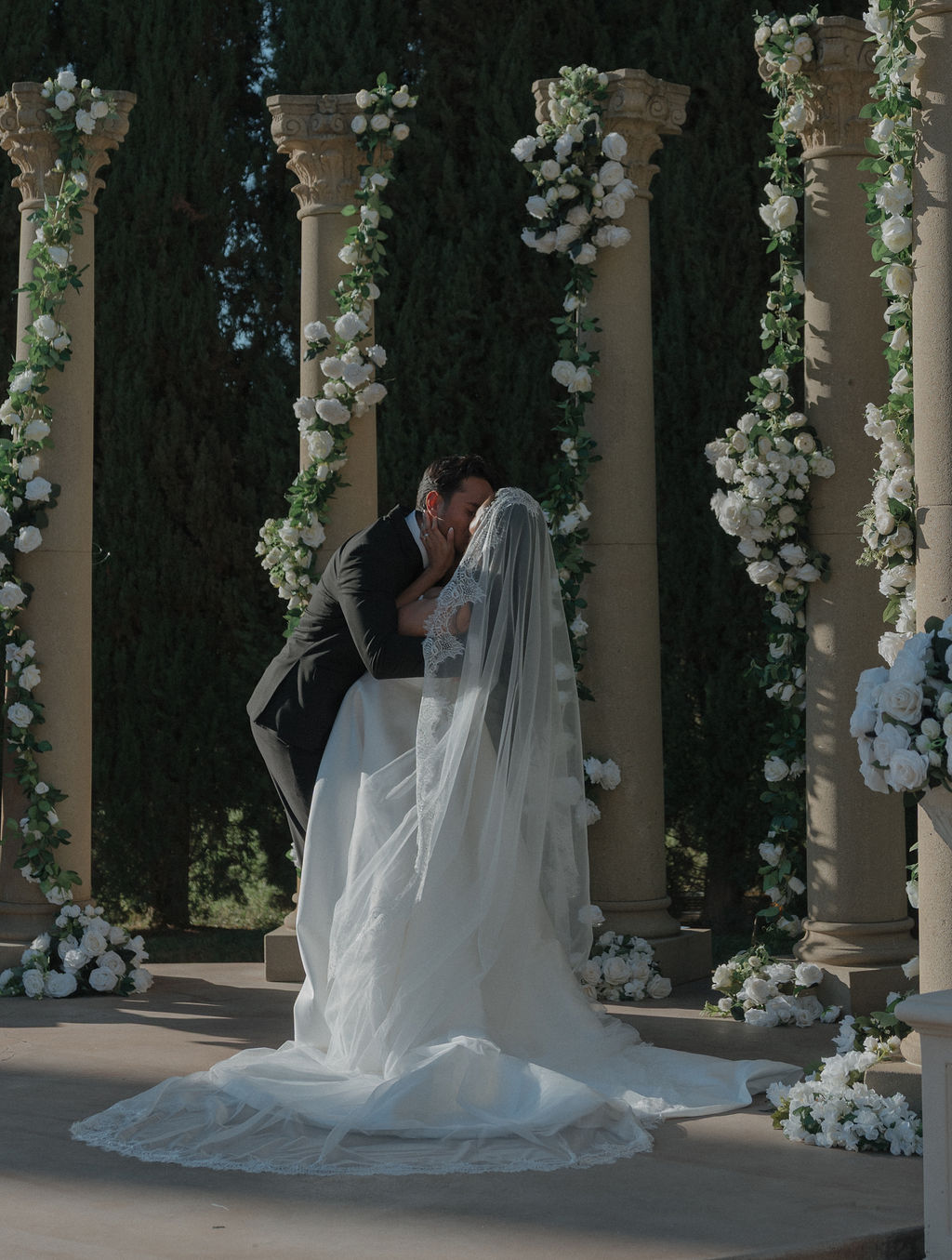 A couple kissing at their grand island mansion wedding ceremony
