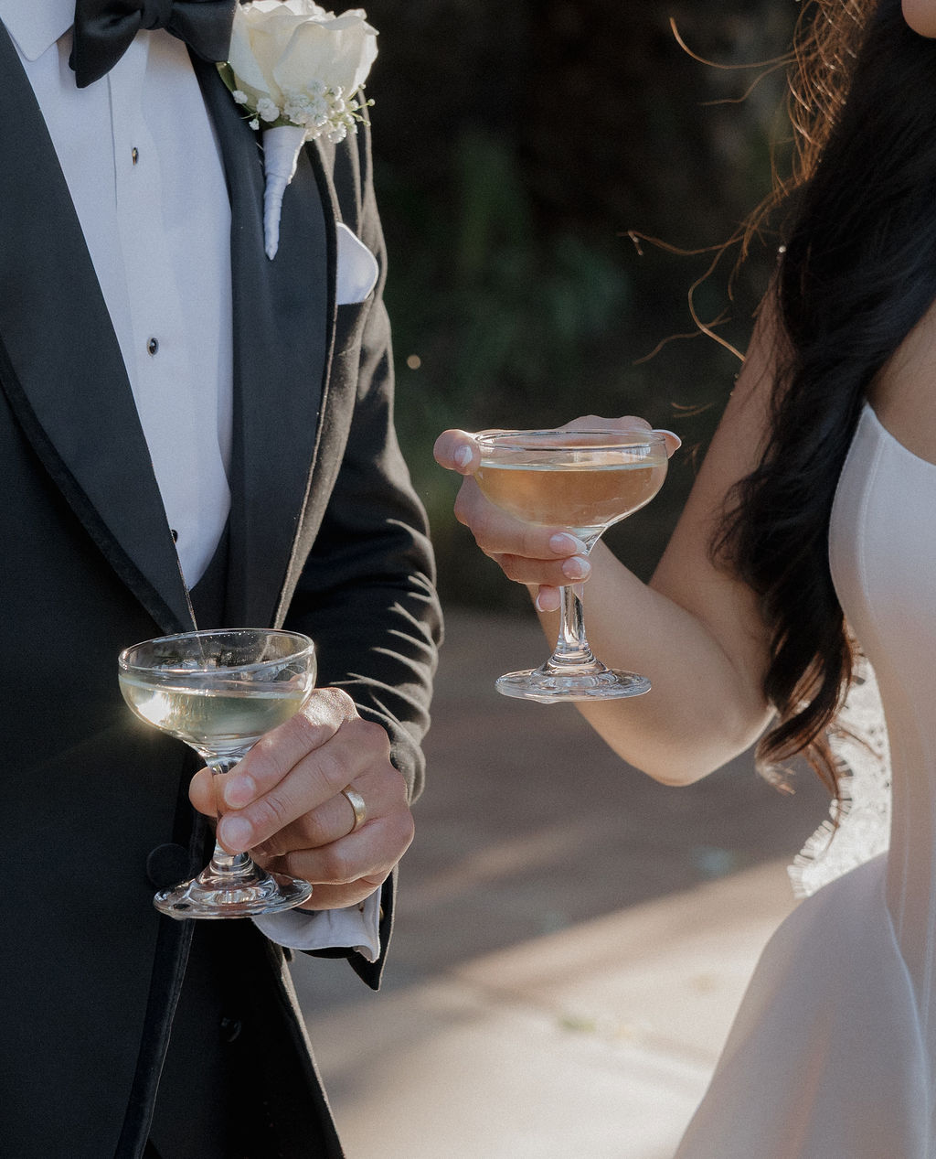 A couple holding champagne coupes in an up close wedding photo