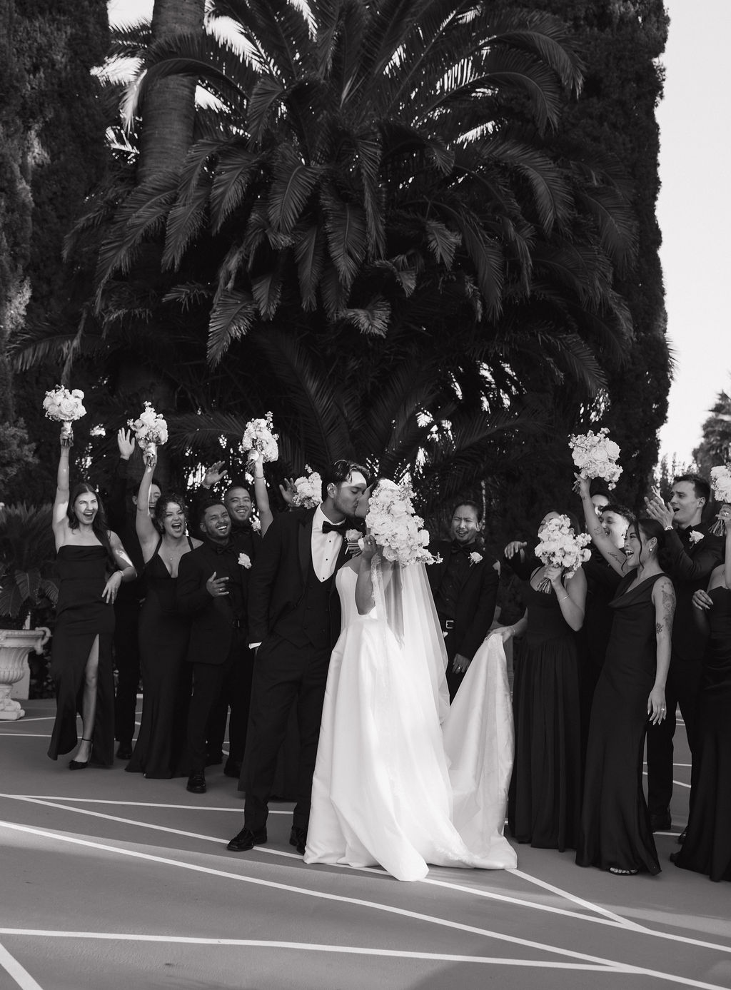 A couple kissing in front of their wedding party at grand island mansion