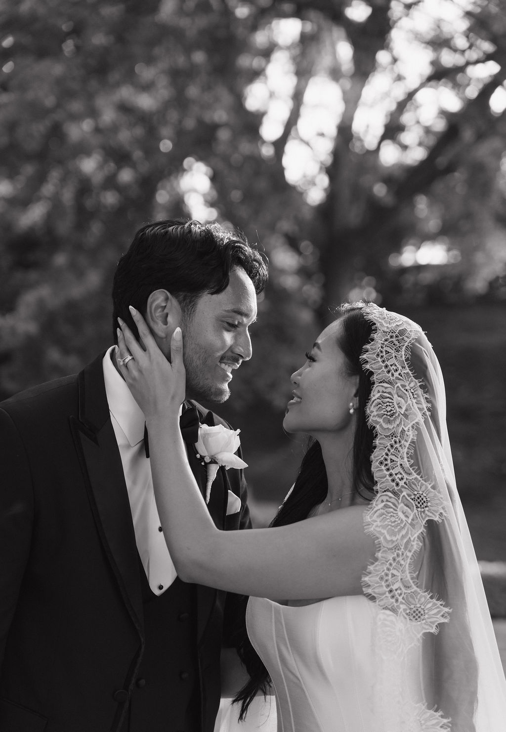 A bride holding a groom's face in a wedding photo