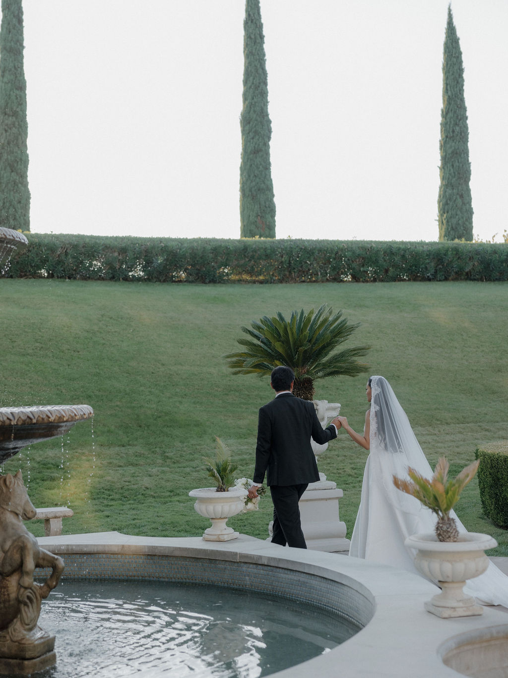A couple walking through the courtyard for wedding photos at grand island mansion