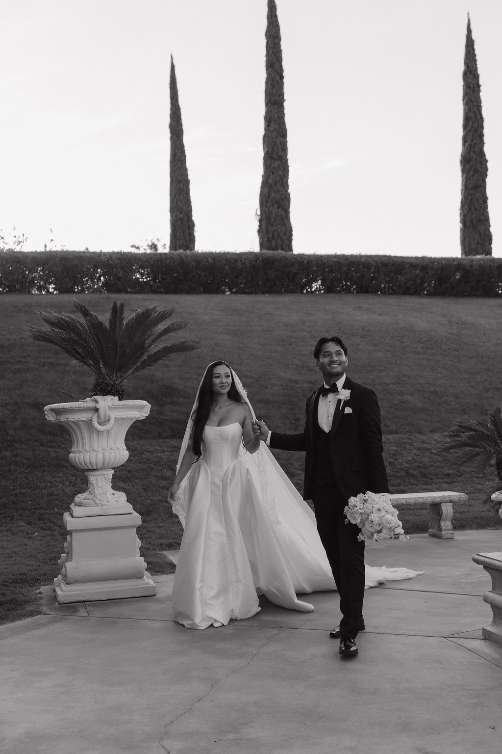 A bride and groom walking across the courtyard at grand island mansion