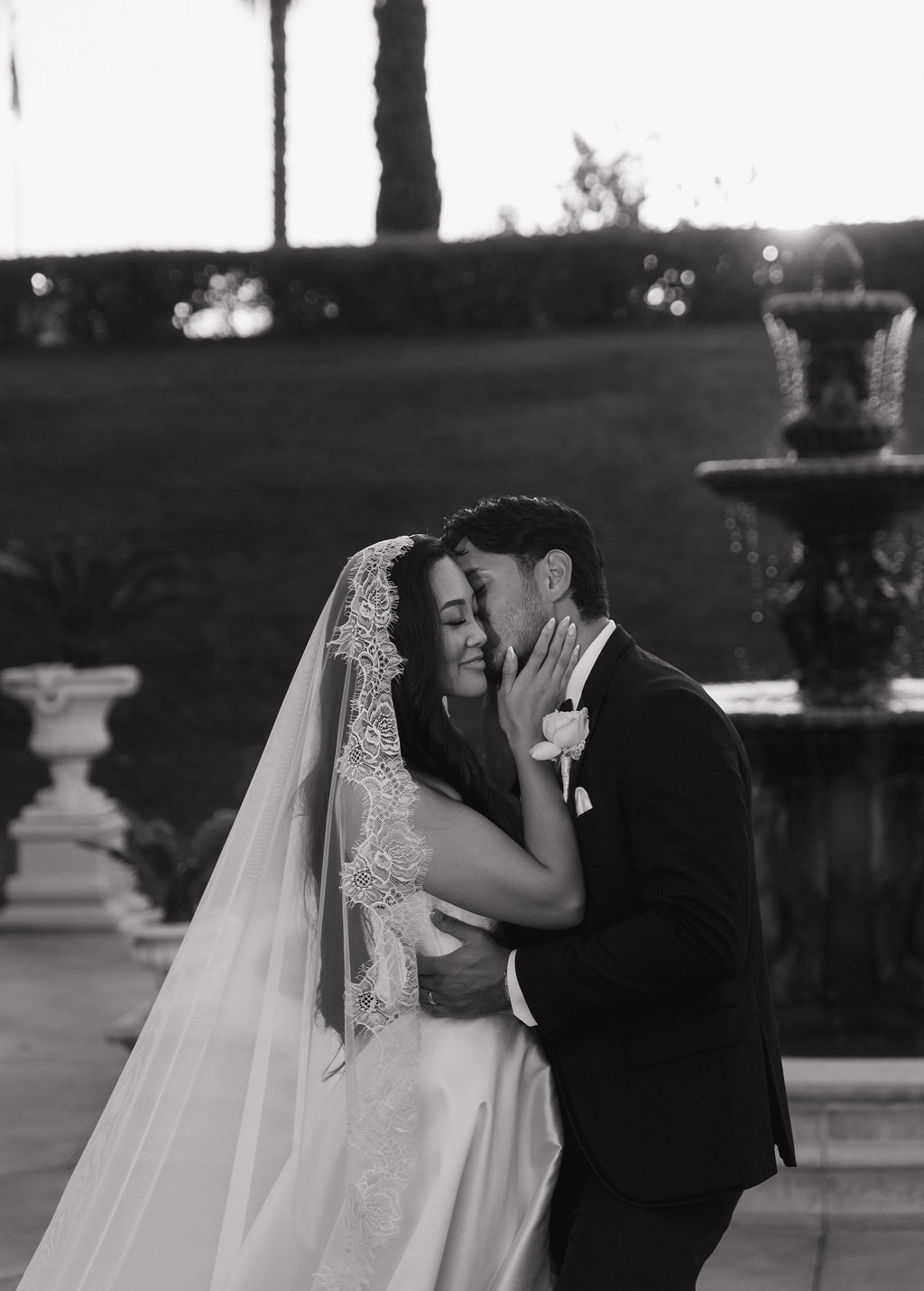 A groom kissing a bride on the cheek at grand island mansion