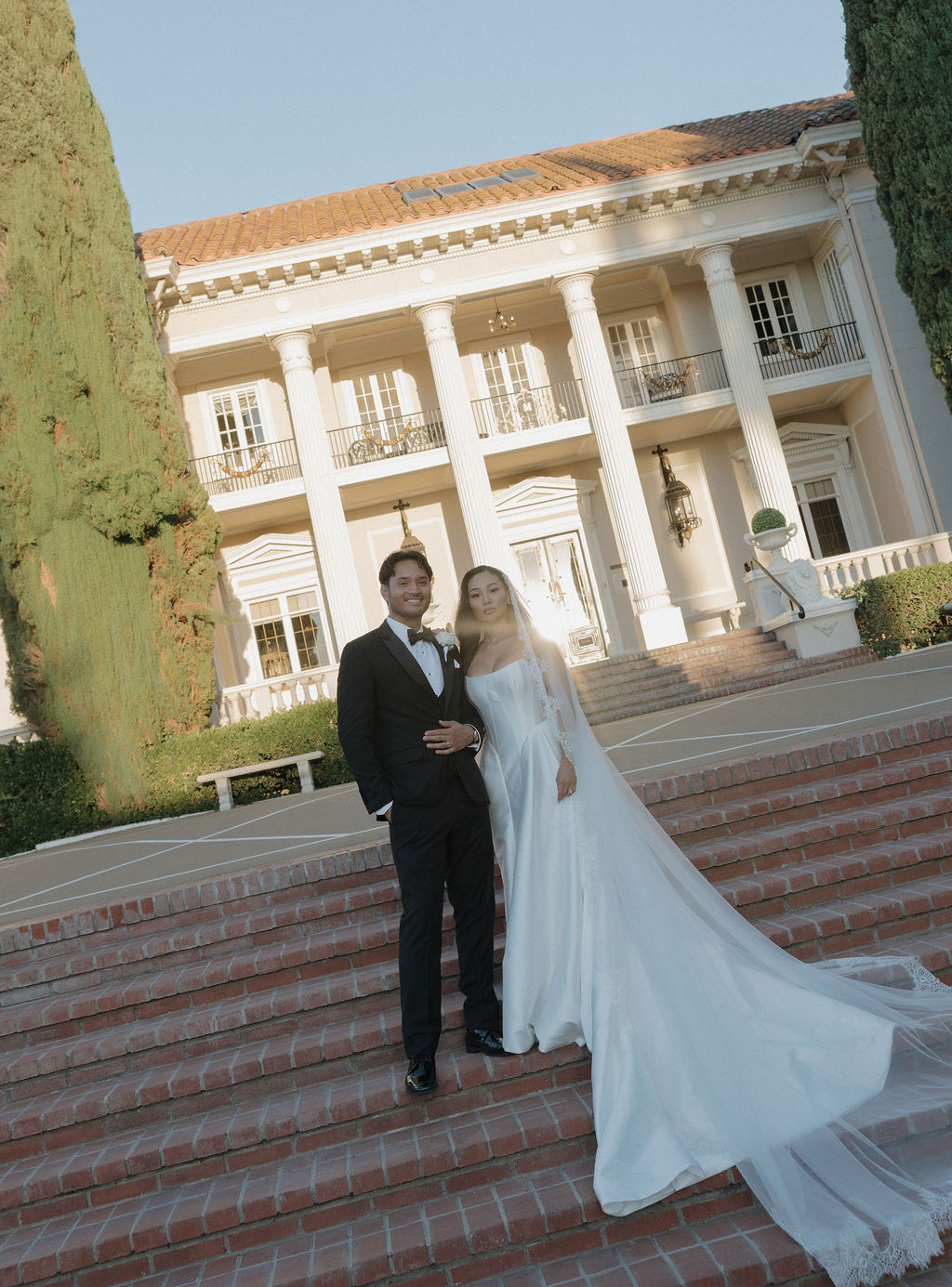 A couple standing on the steps at grand island mansion for their wedding