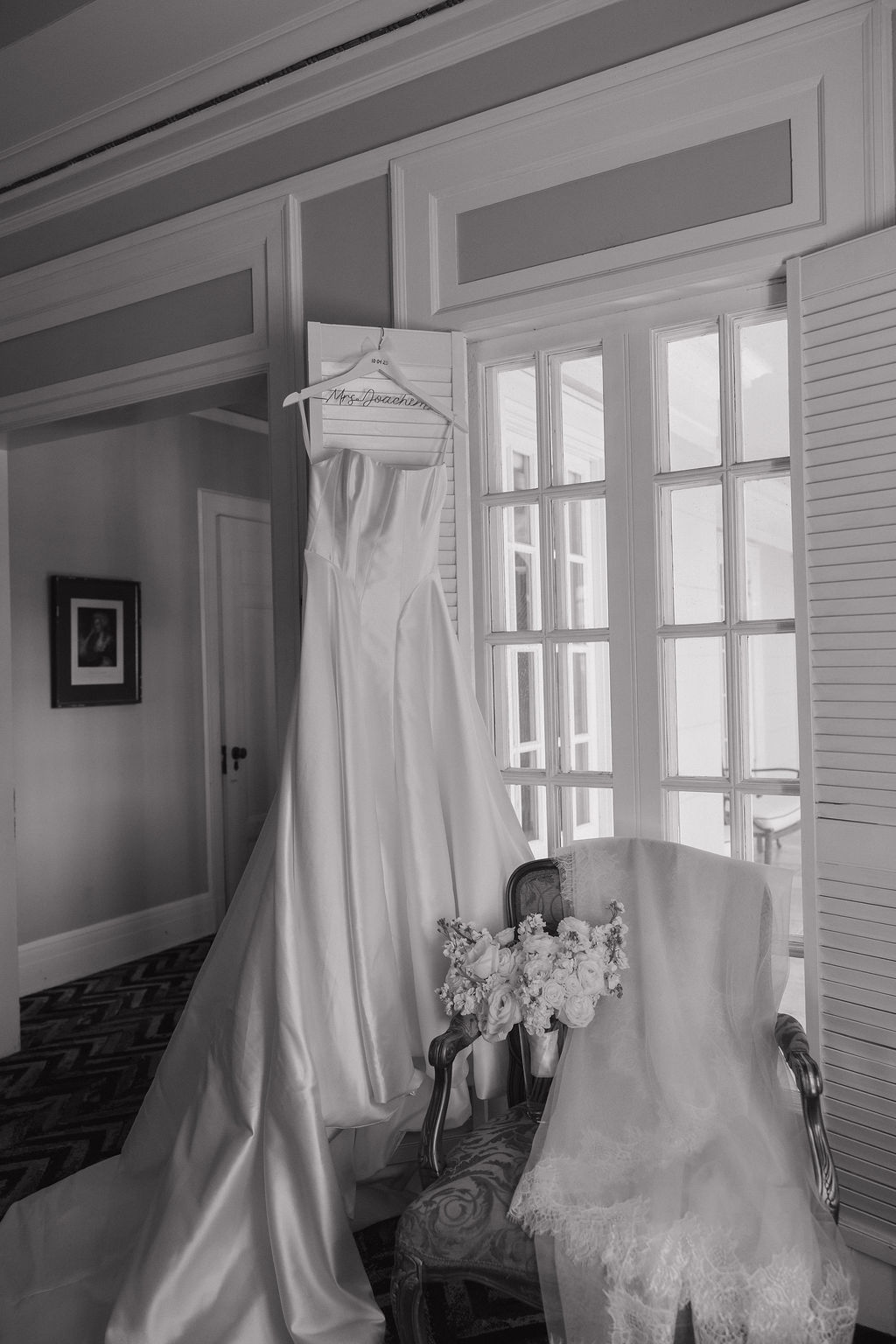 A wedding dress hanging up inside the get ready rooms at grand island mansion